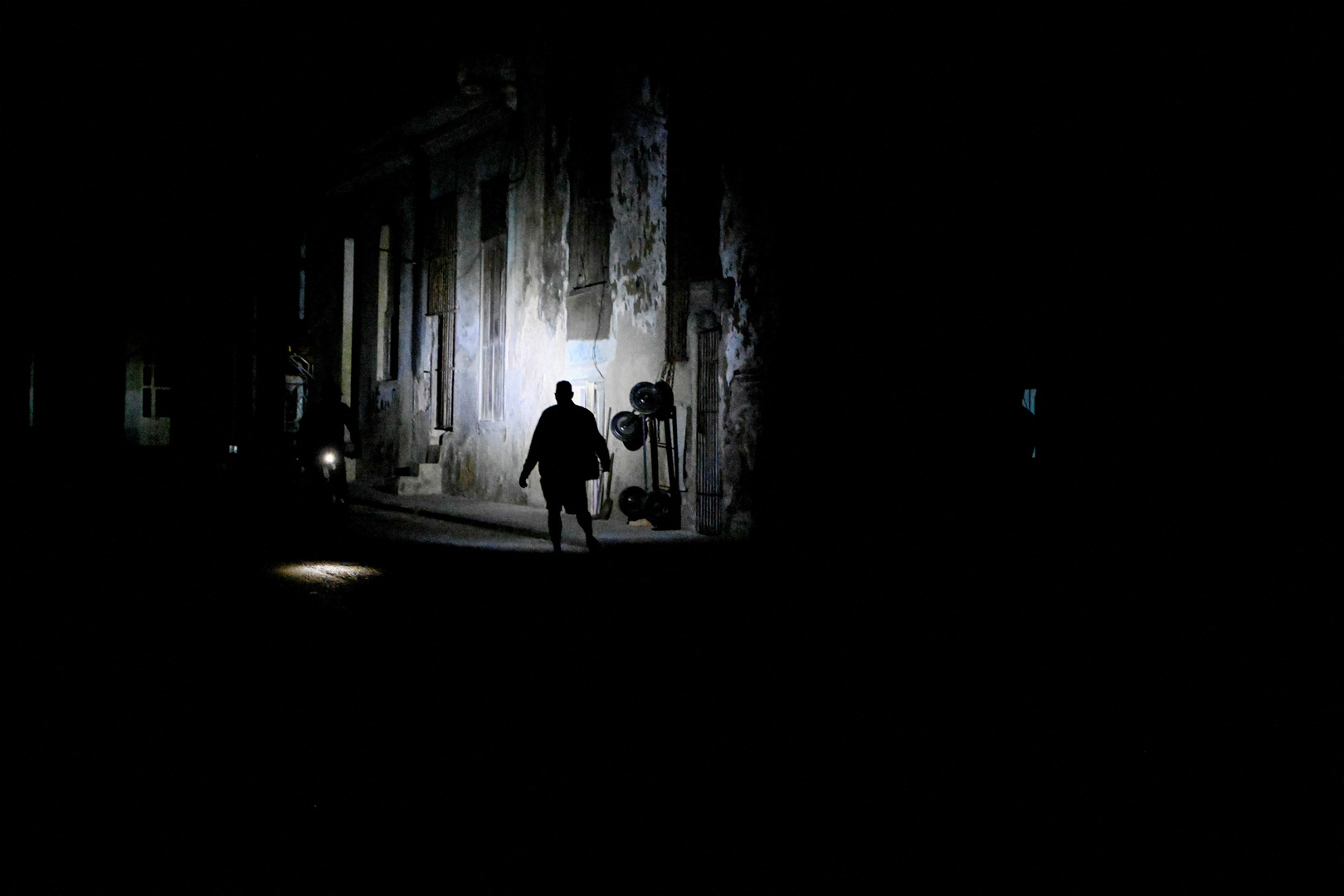 A man walks on a street as Cuba's national electric grid collapsed for the second time in a week amid the US-imposed oil blockade, according to officials, as the communist government struggles to keep the lights on for about 10 million people with decrepit infrastructure, in Havana, Cuba on March 21, 2026. [Norlys Perez/Reuters]