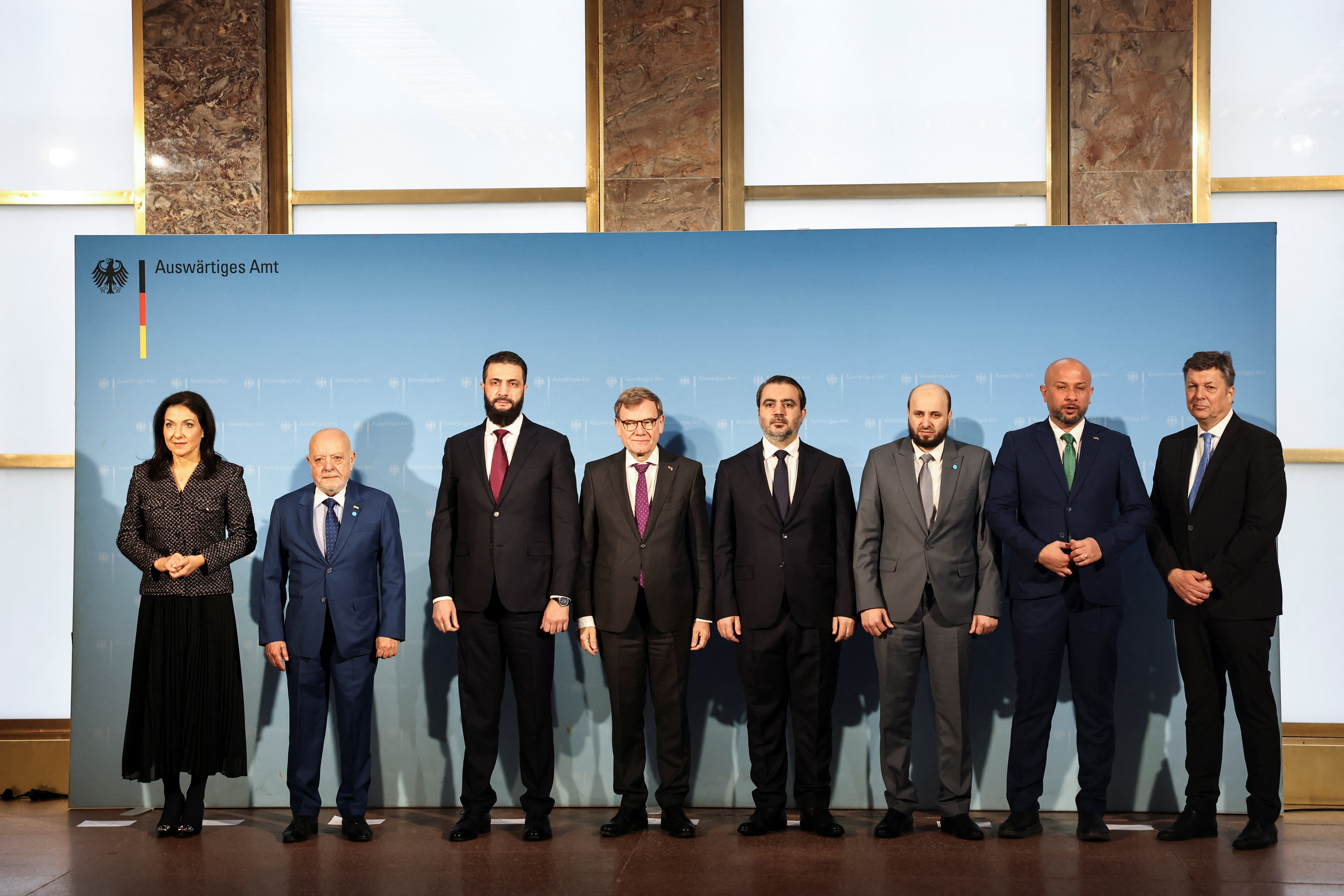 Syrian President Ahmed al-Sharaa and German Foreign Minister, Johann Wadephul, pose for a family photo with Syrian Minister of Emergency and Disaster Management, Raed al-Saleh, Member of the Executive Board of the Federation of German Industries, Wolfgang Niedermark, Syrian Foreign Minister, Asaad Hassan al-Shaibani, Syrian Economy Minister, Mohammad Nidal al-Shaar, Syrian Energy Minister, Mohammed Al-Bashir and German Economy and Energy Minister, Katherina Reiche, in Berlin, Germany, March 30, 2026. REUTERS/Nadja Wohlleben
