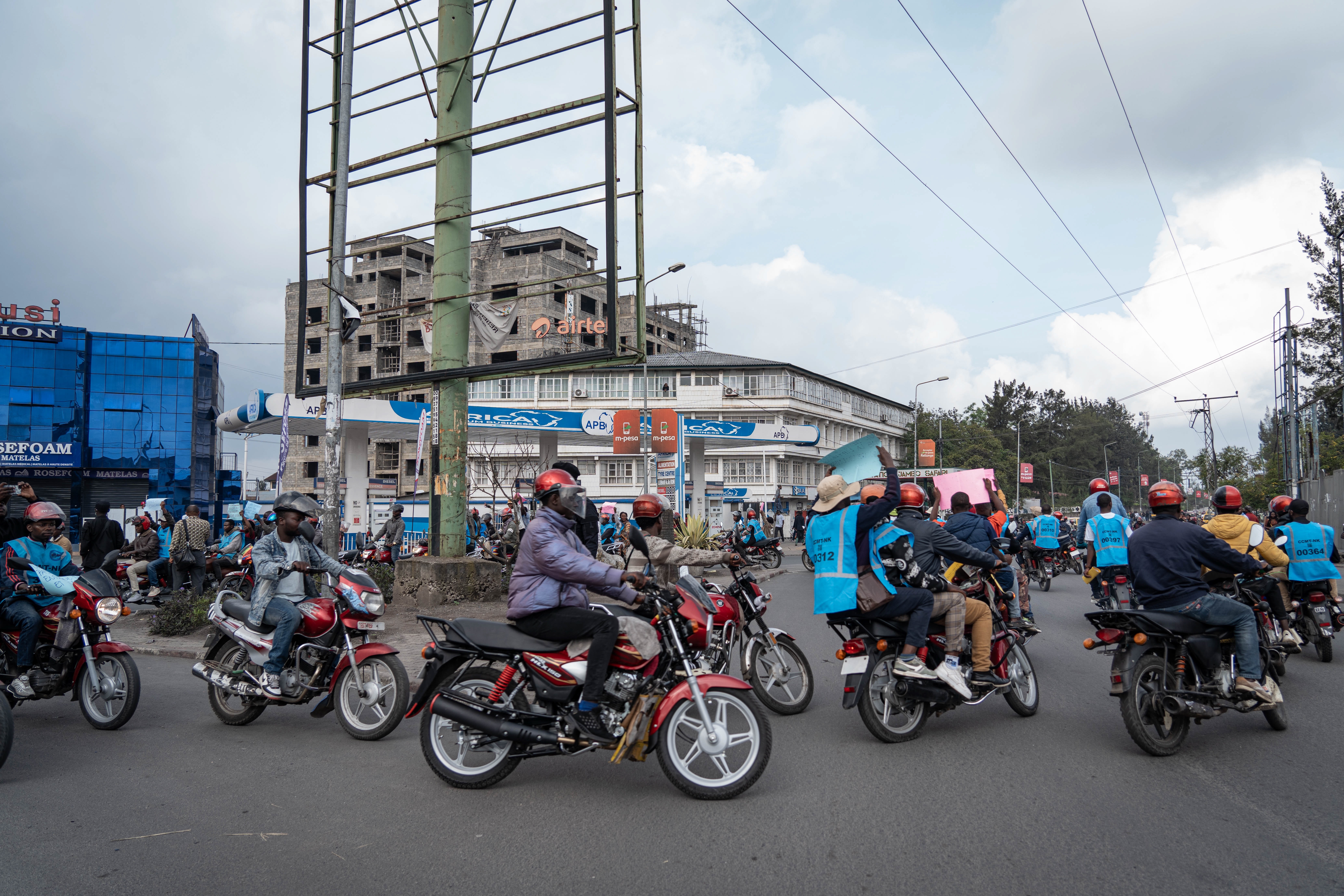 Activists hold signs denouncing the war during a march in Goma, North Kivu, DR Congo on March 12, 2026.