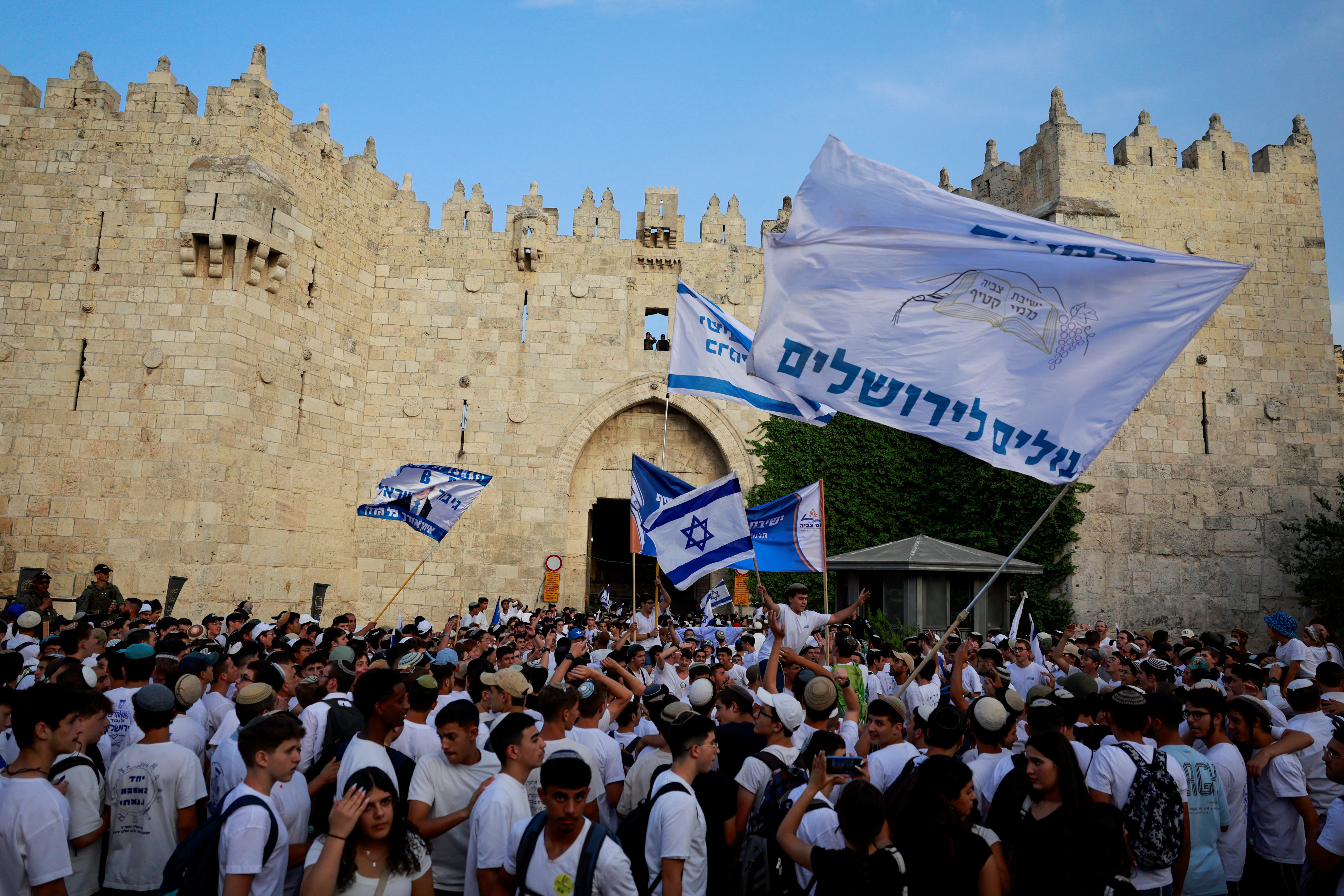 Israelis gather with flags by Damascus Gate to Jerusalem's Old City.