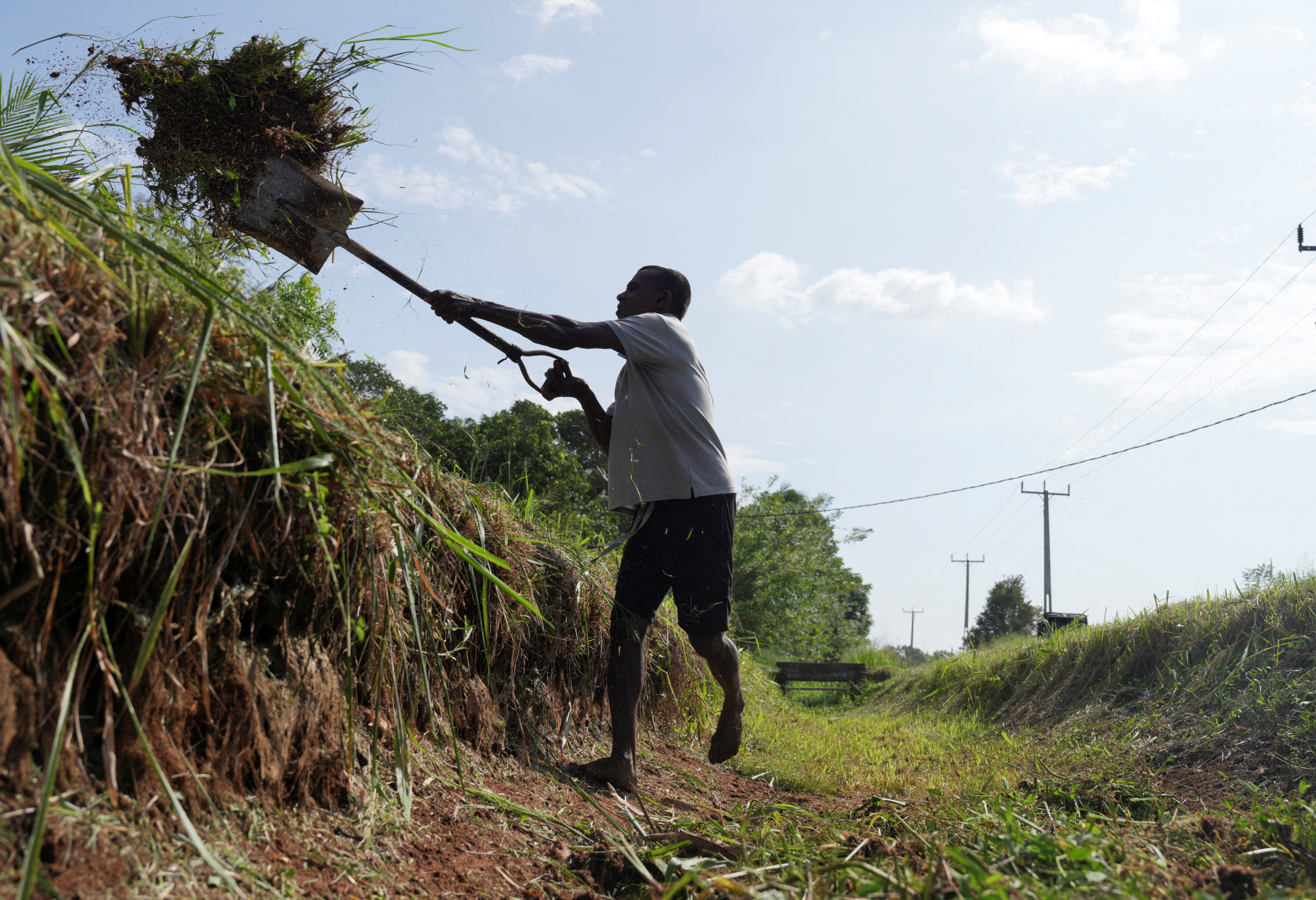 A man using a shovel to clear a canal in Sri Lanka