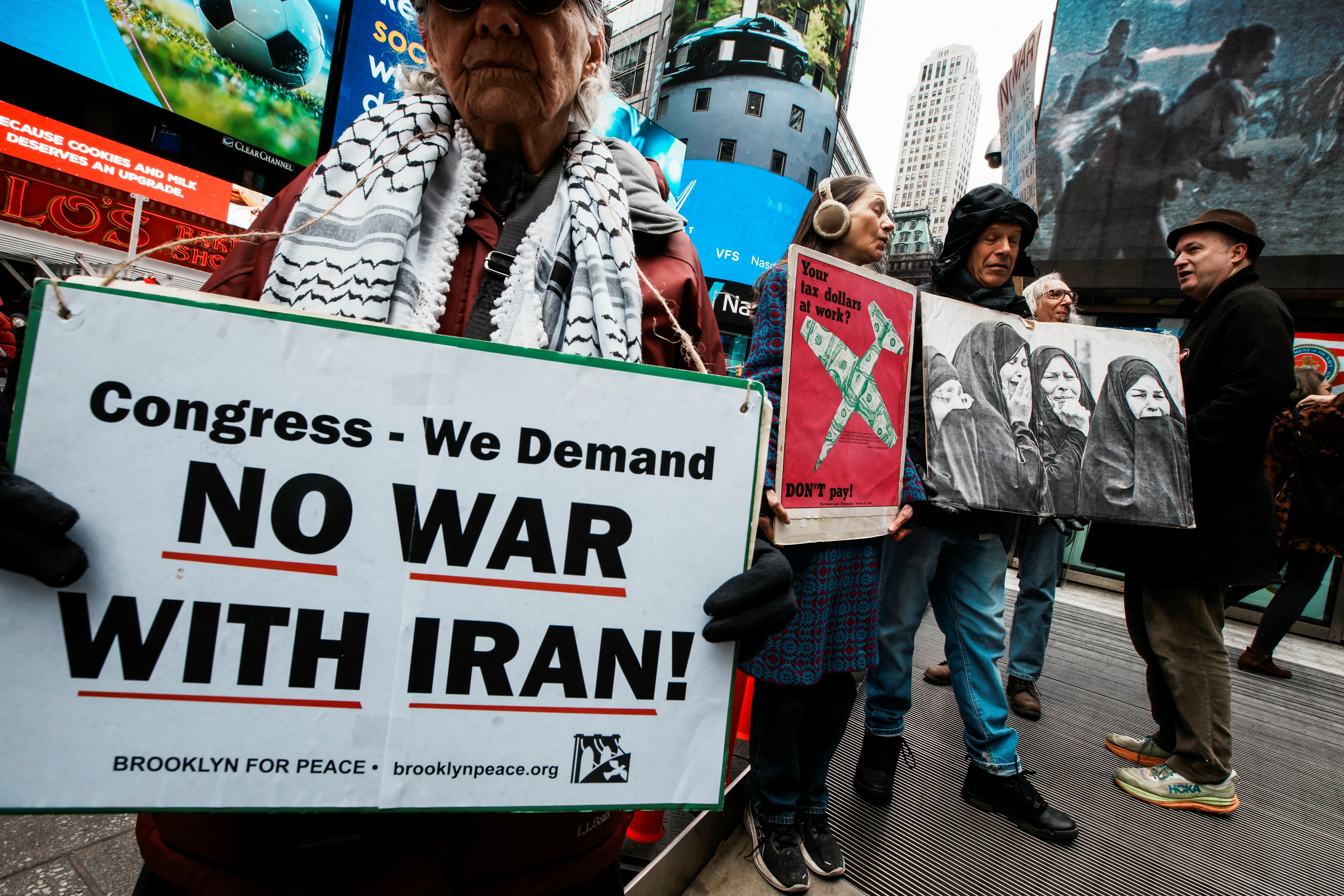 People attend a 'No More War' protest, marking the anniversary of the US-led invasion of Iraq, outside a military recruiting station in Times Square, in New York