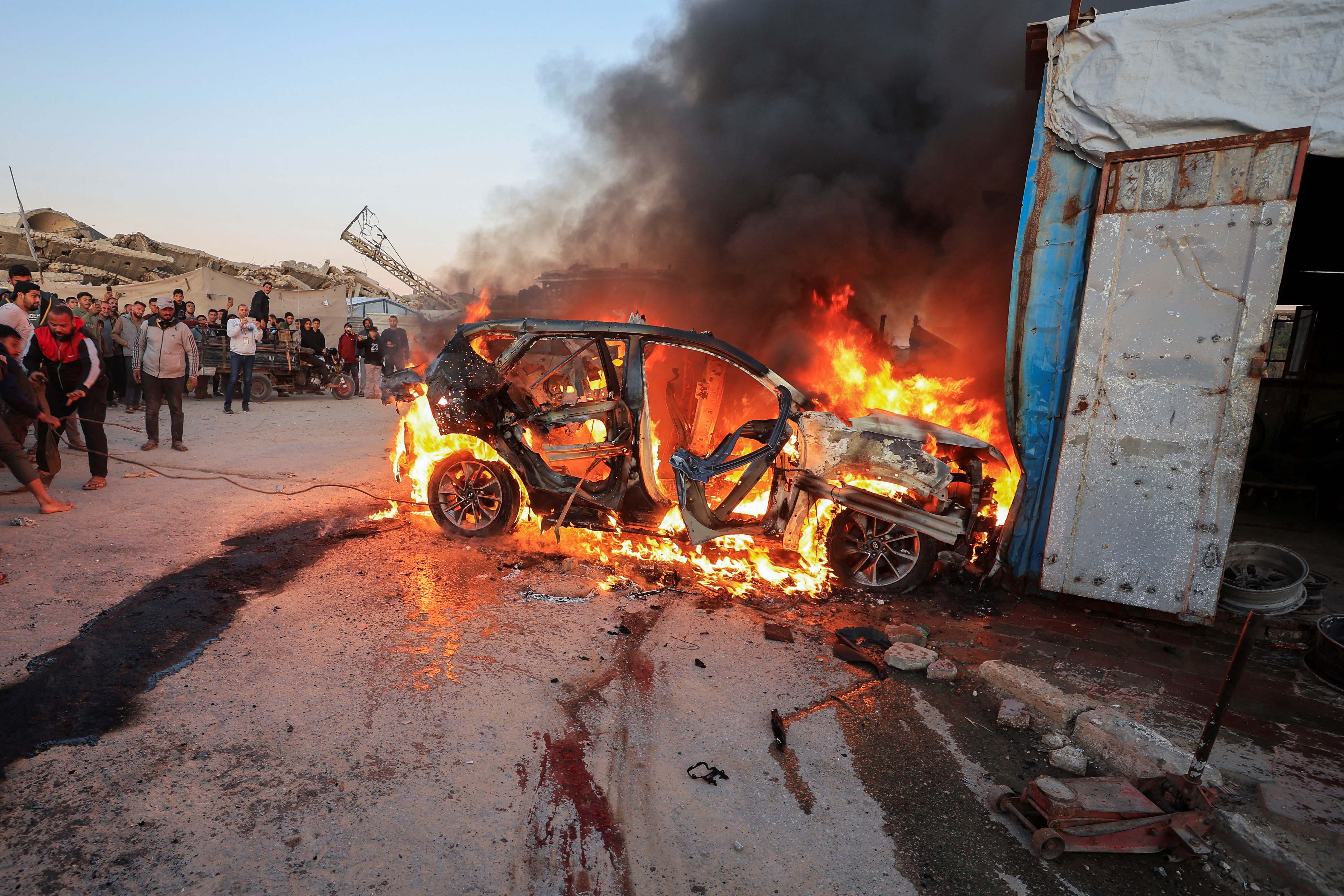 People stand near a burning vehicle following an Israeli strike that killed Al Jazeera journalist Mohammad Weshah, according to medics, in Gaza City April 8, 2026. [Dawoud Abu Alkas/Reuters]