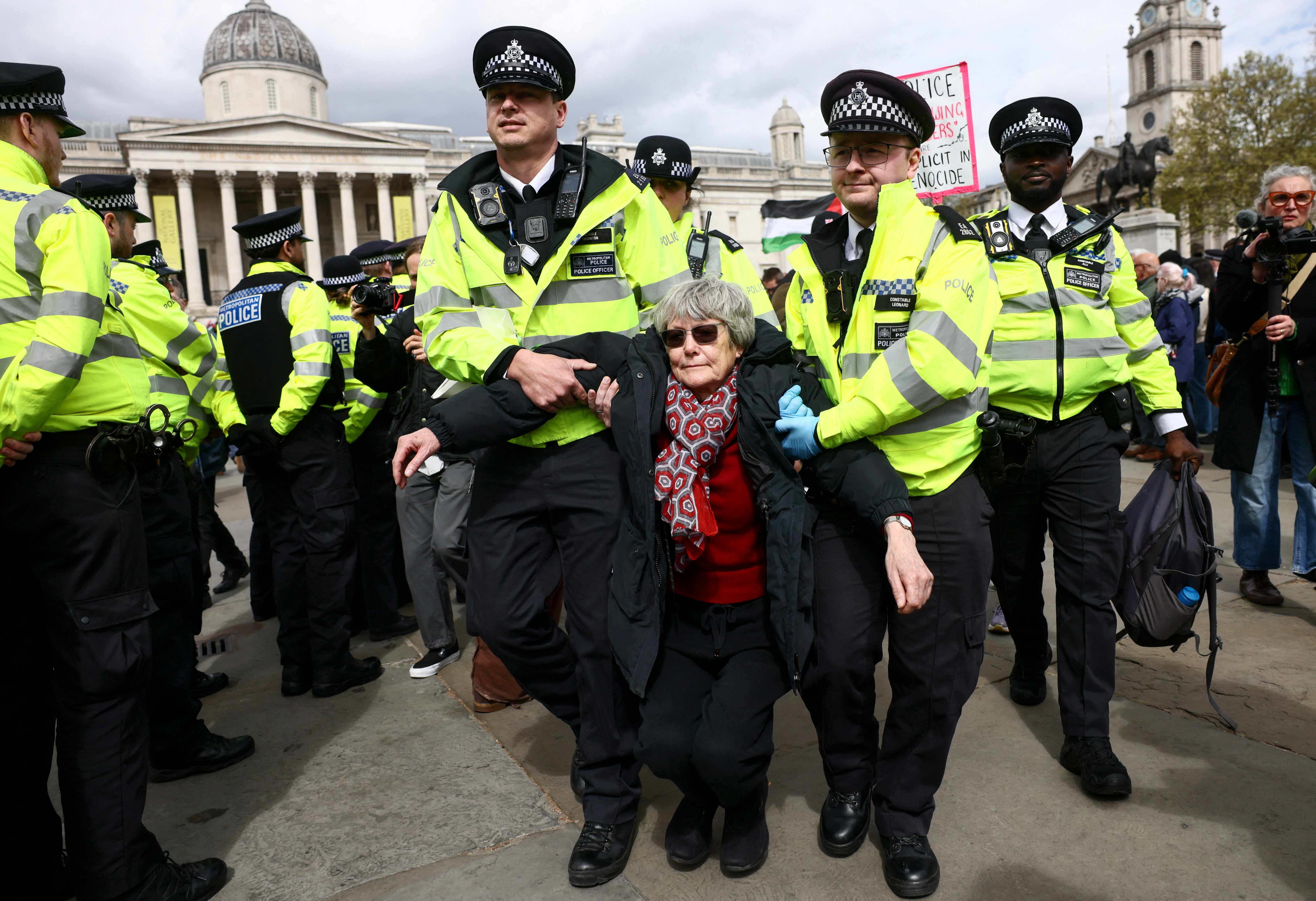Police officers detain a protester