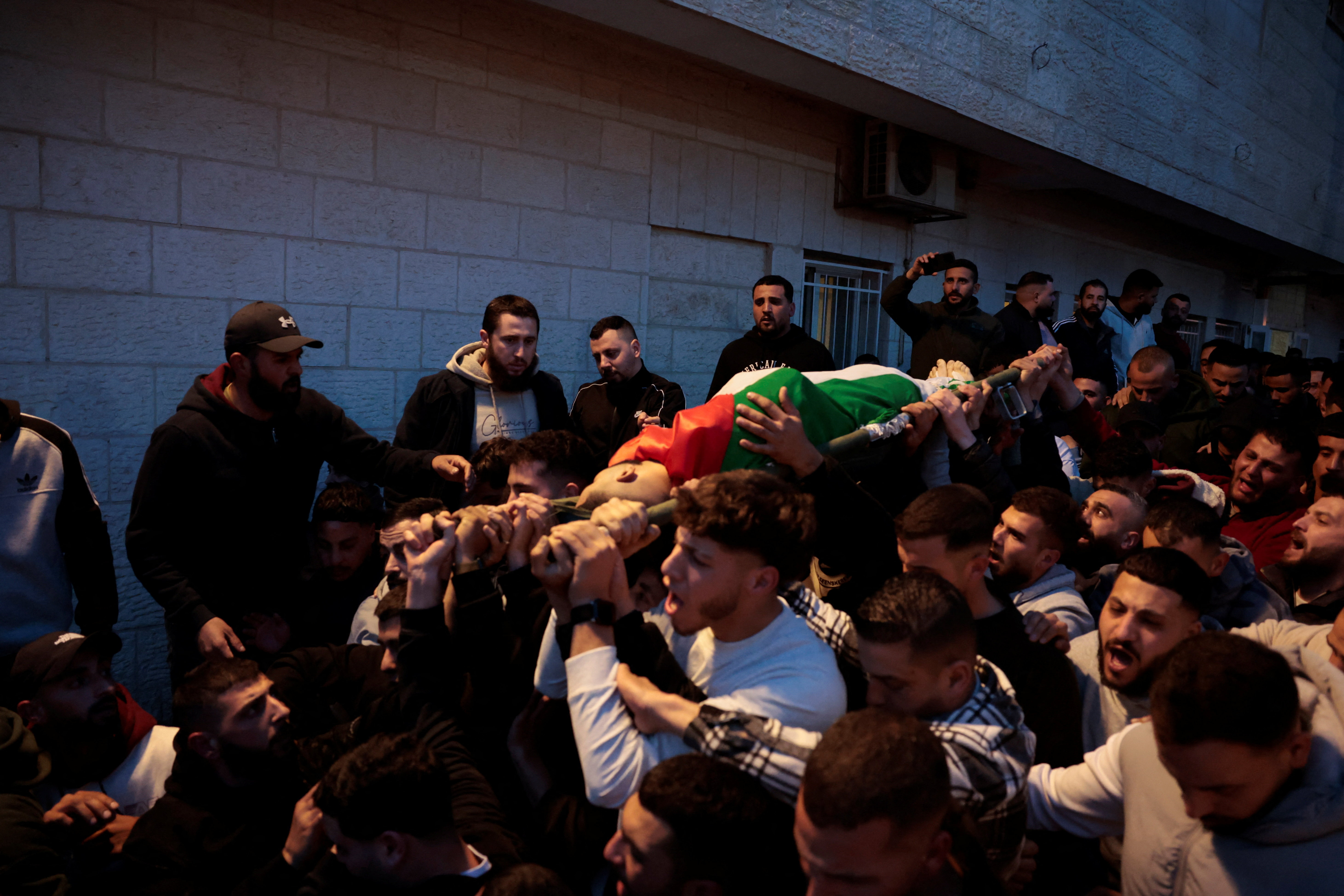 People carry the body of Palestinian Majed Hamadneh