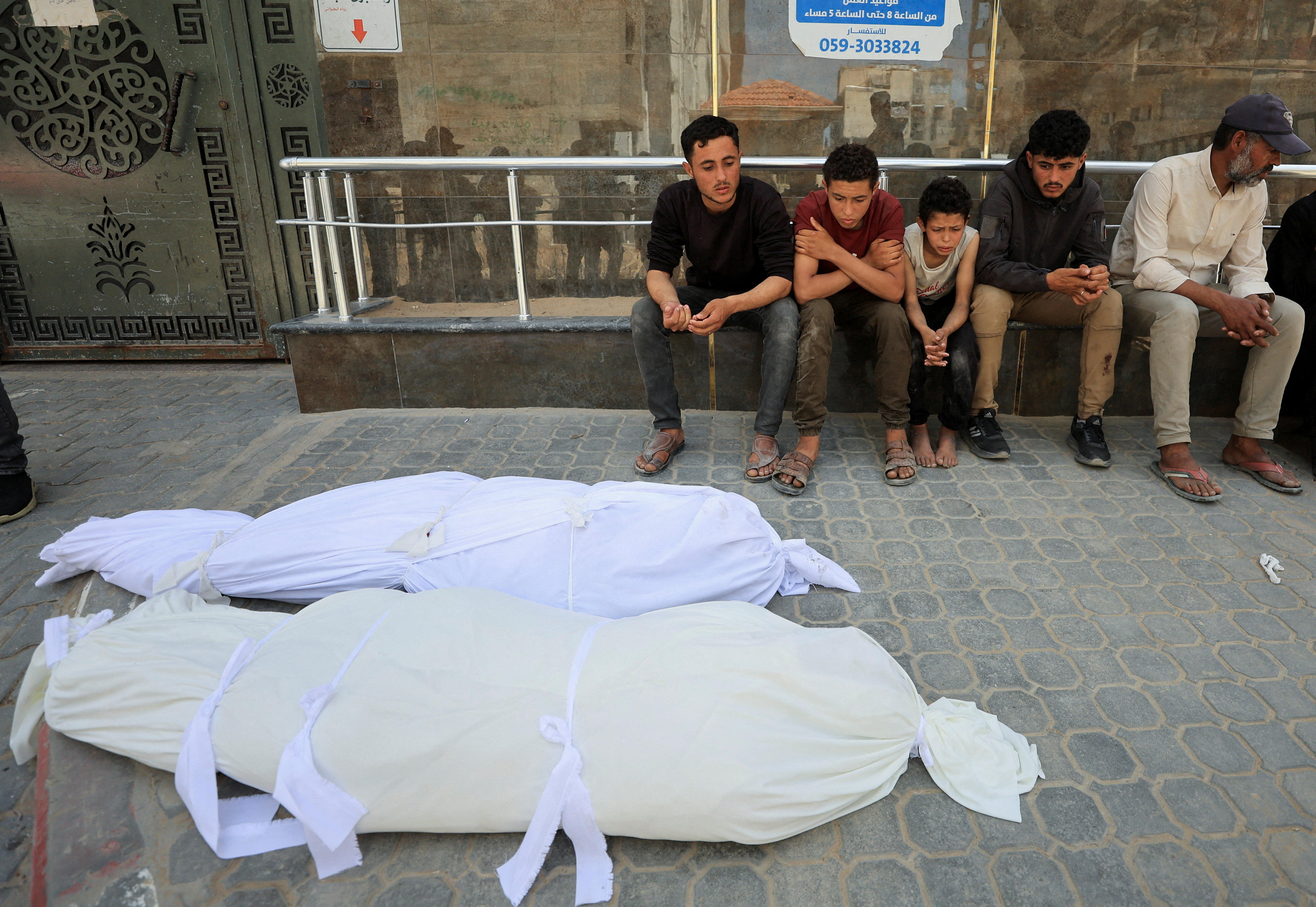People mourn next to the bodies of Palestinian brothers Abdel Malek and Abdel Sattar Al-Attar killed in Gaza