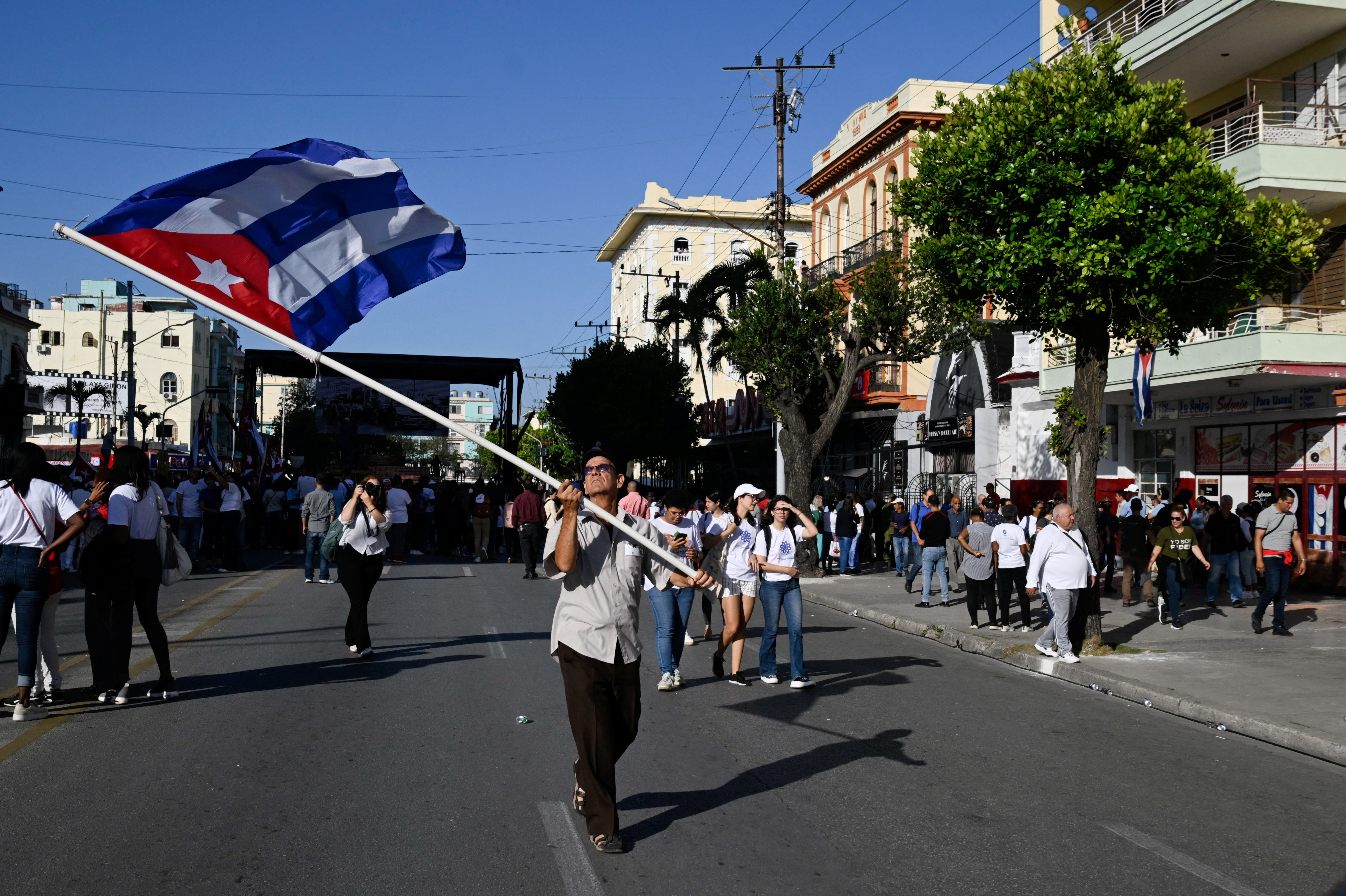 A man waves a Cuban flag after a ceremony marking the 65th anniversary of Fidel Castro's declaration of the socialist character of the Cuban Revolution, made on the eve of the Bay of Pigs invasion in 1961, in Havana,