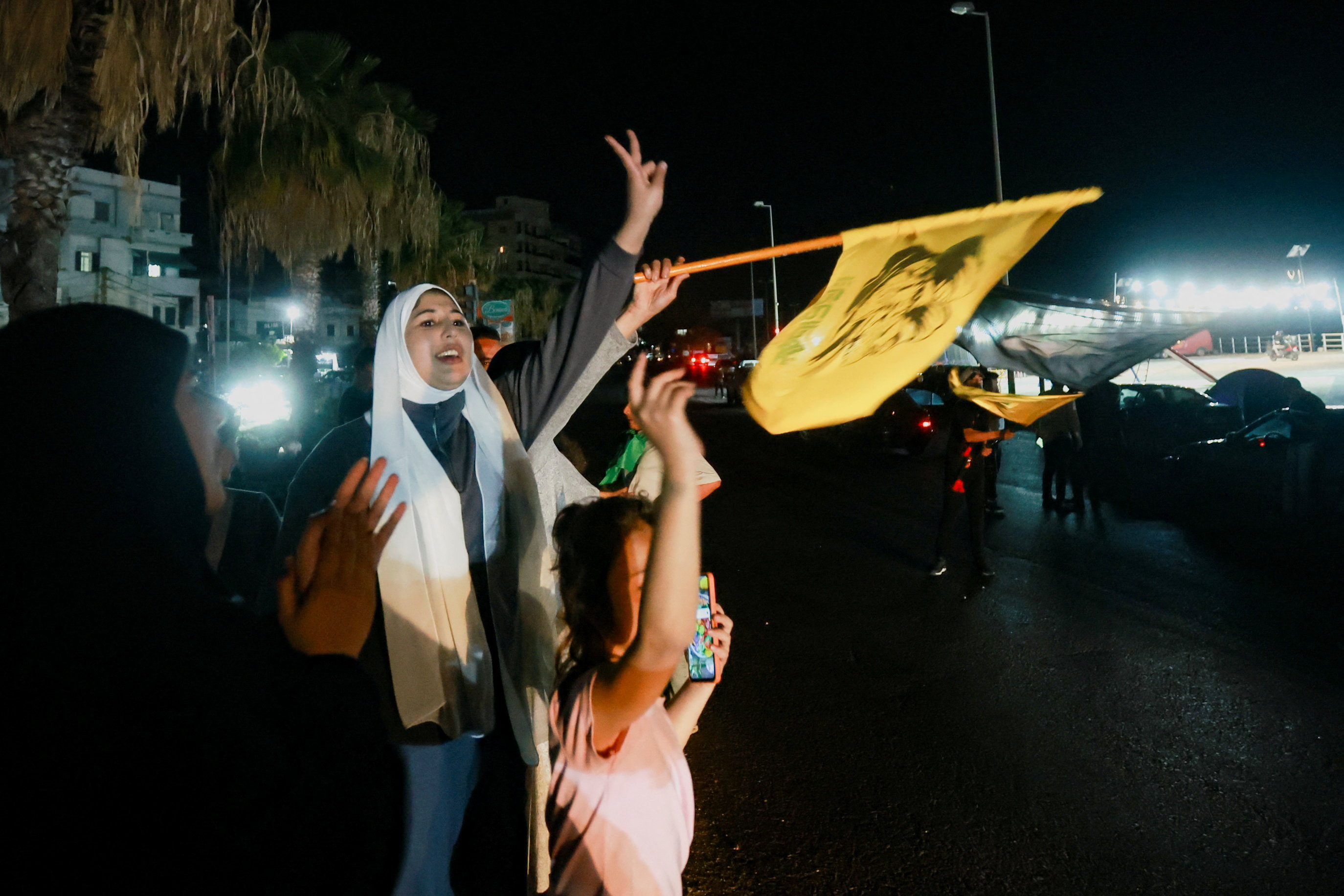 A women and a child celebrate and wave a flag.