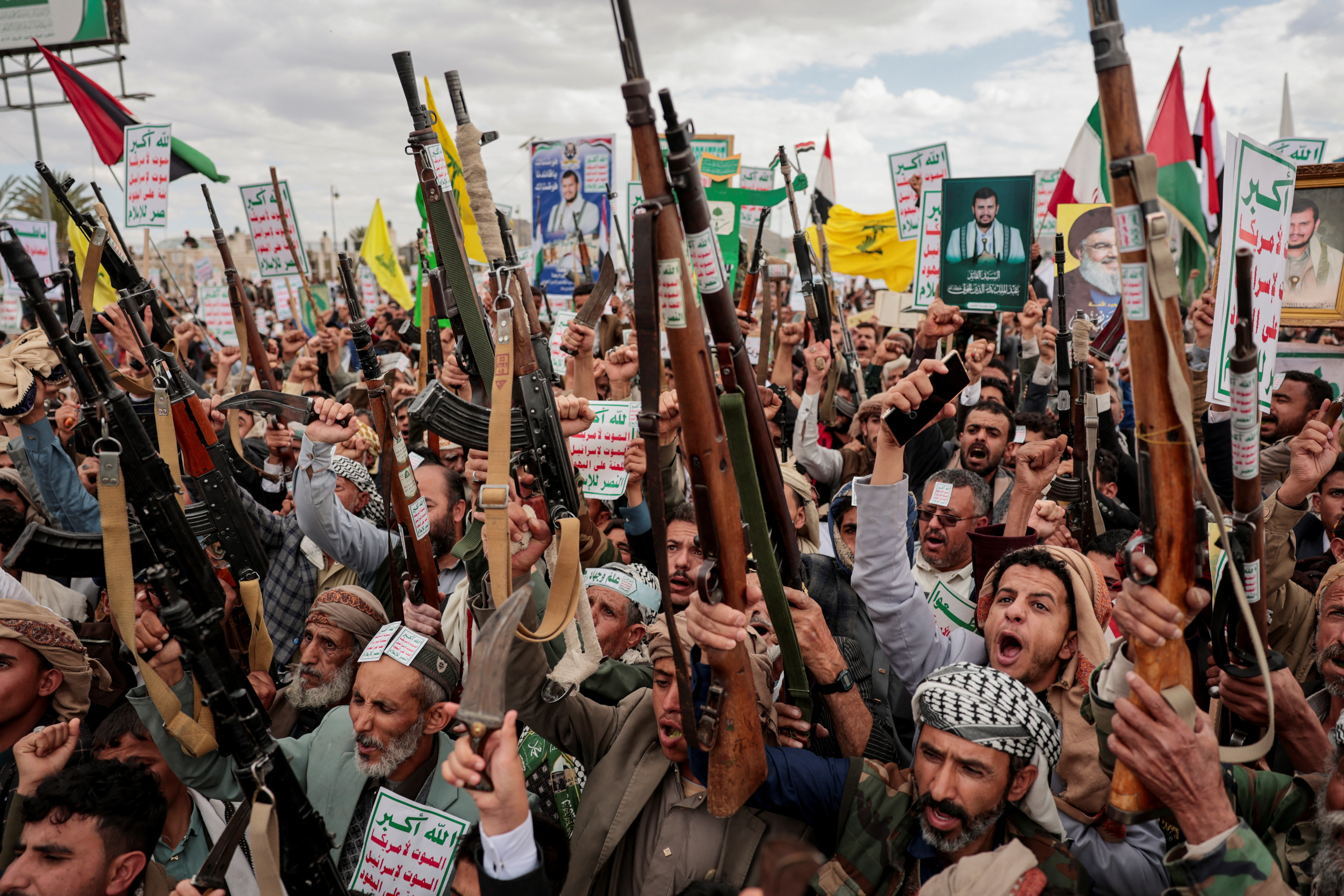 Demonstrators hold up guns and chant during the protest