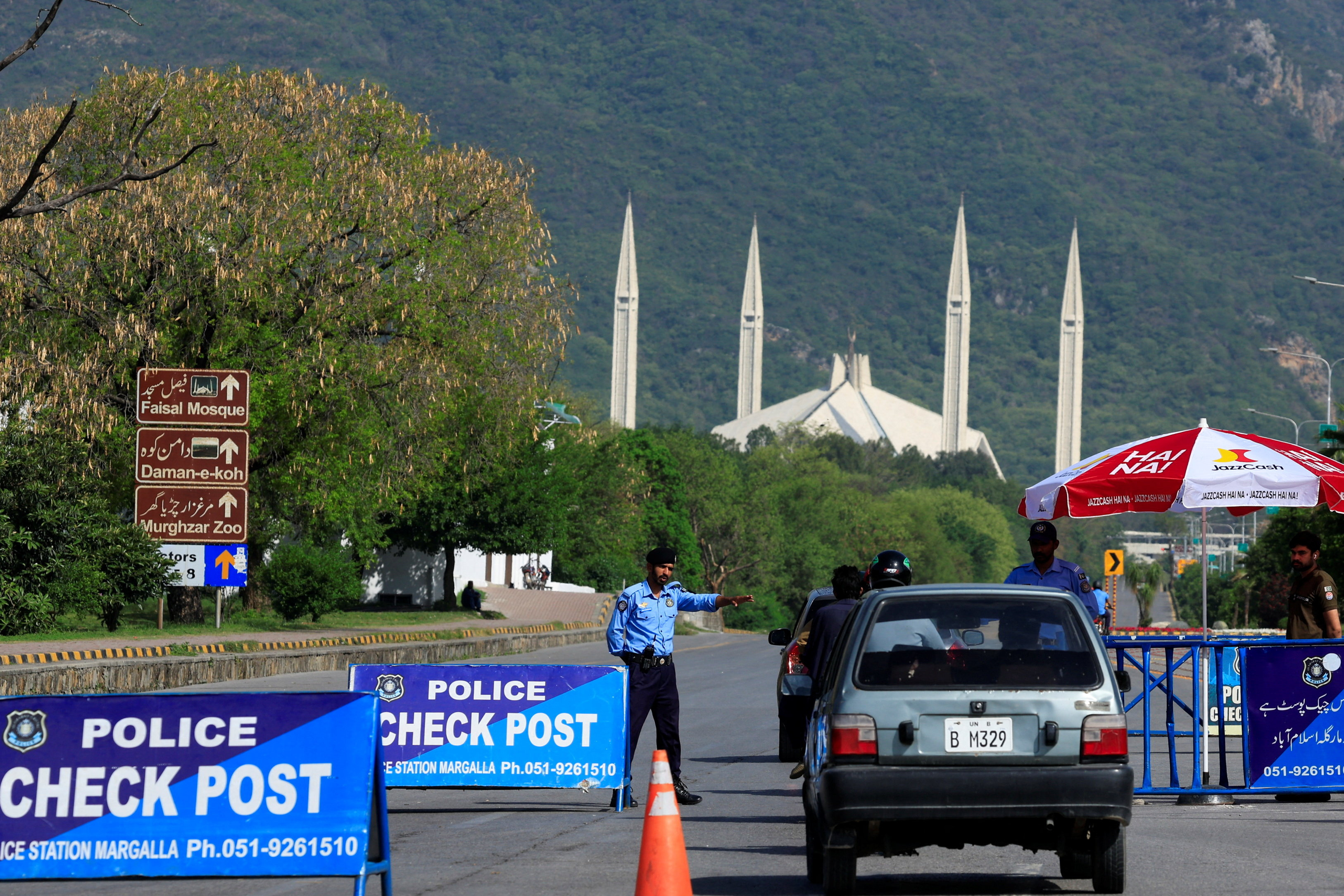 A police officer gestures to a vehicle at a check post along a road near Faisal Masjid, as Pakistan prepares to host the U.S. and Iran for the second phase of peace talks in Islamabad, Pakistan April 19, 2026.