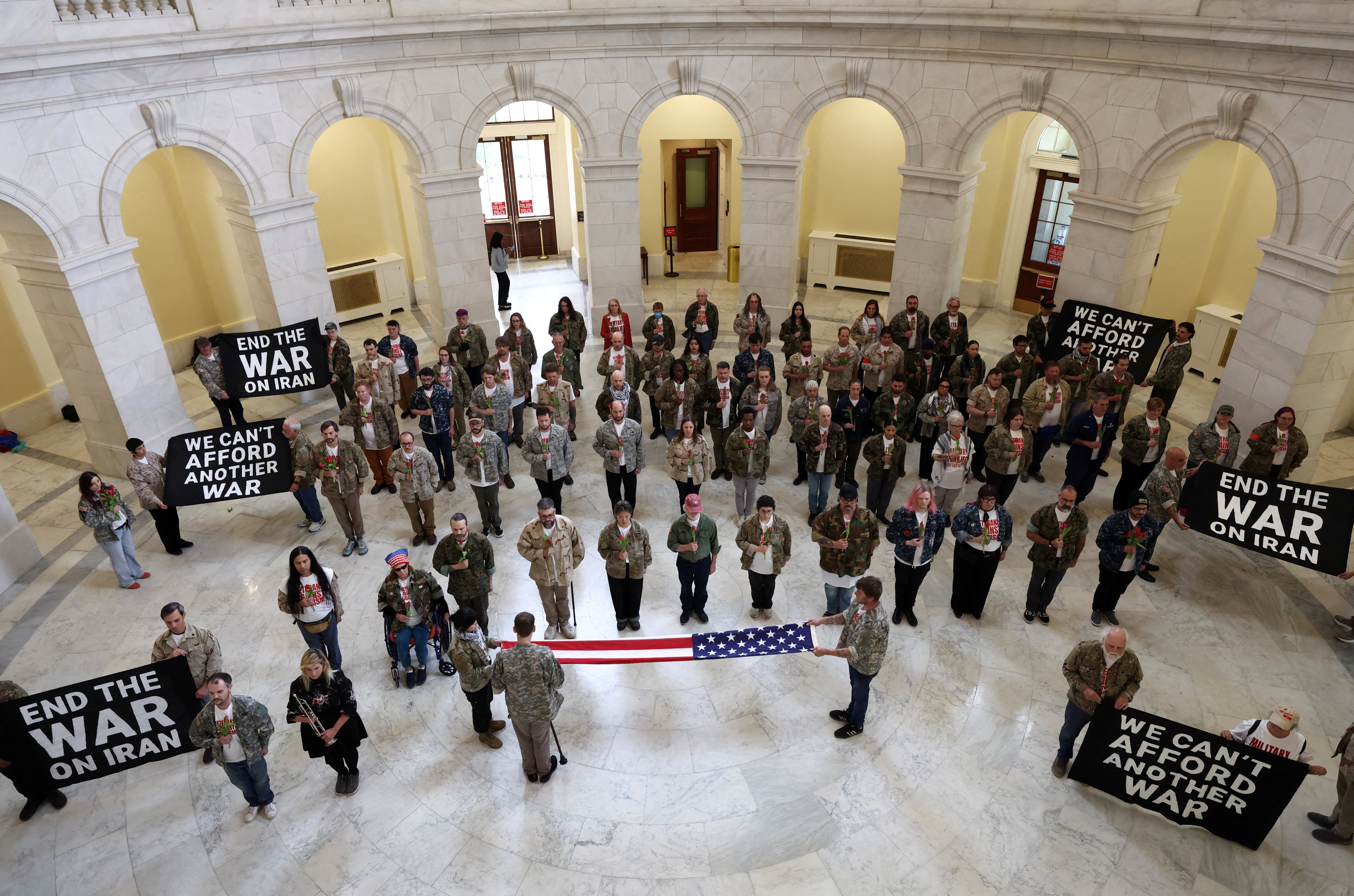 Veterans with the group About Face perform a flag-folding ceremony as they protest against the Iran war, in the Cannon House Office Building Rotunda on Capitol Hill in Washington, D.C.