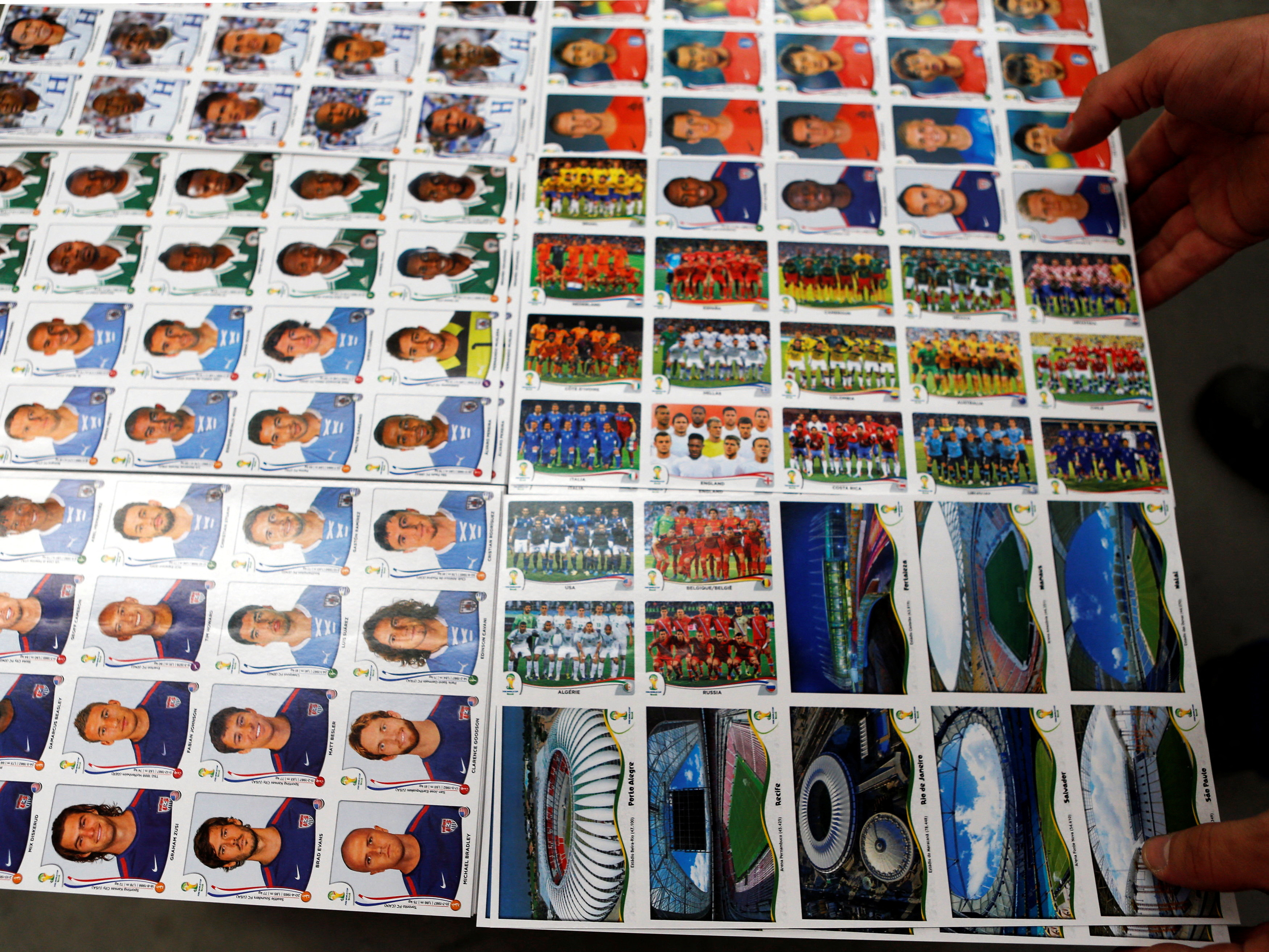 FILE PHOTO: A labourer works at the assembly line of Panini's factory, where FIFA's Brazil World Cup stickers and albums are produced, in Tambore, an industrial suburb north of Sao Paulo May 5, 2014. The World Cup is around the corner and millions of fans are putting down their iPads to collect and trade soccer stickers, a decades-old hobby that has defied the digital age. Picture taken May 5, 2014. REUTERS/Paulo Whitaker (BRAZIL - Tags: SPORT SOCCER WORLD CUP SOCIETY BUSINESS)/File Photo