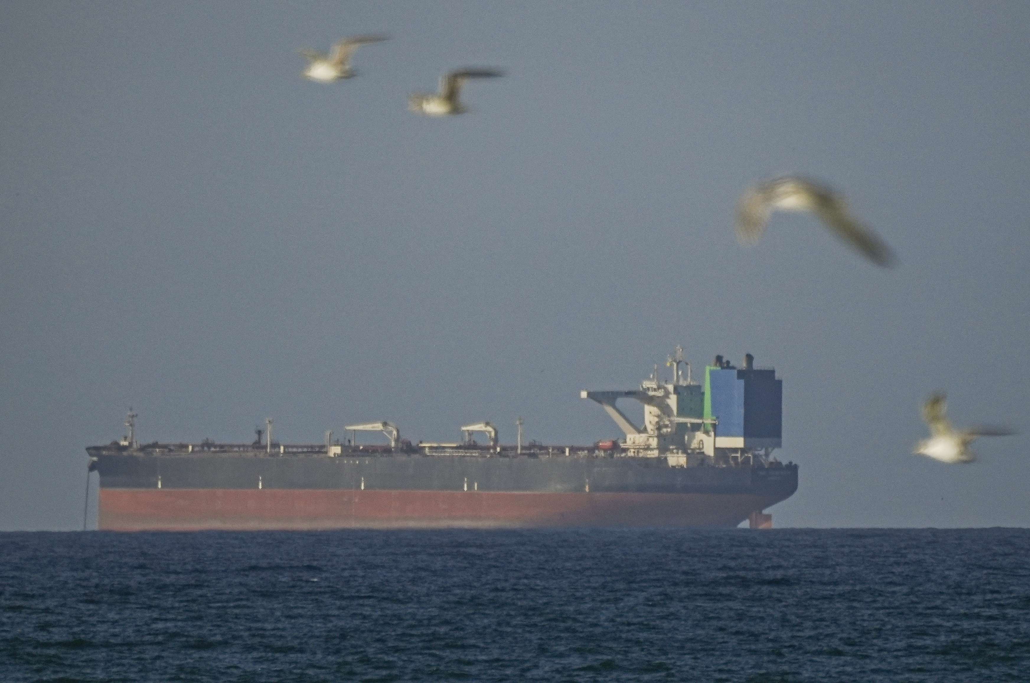 A ship waits to pass through the Strait of Hormuz following the two-week temporary ceasefire between the US and Iran, which is conditional on the opening of the strait, in Oman