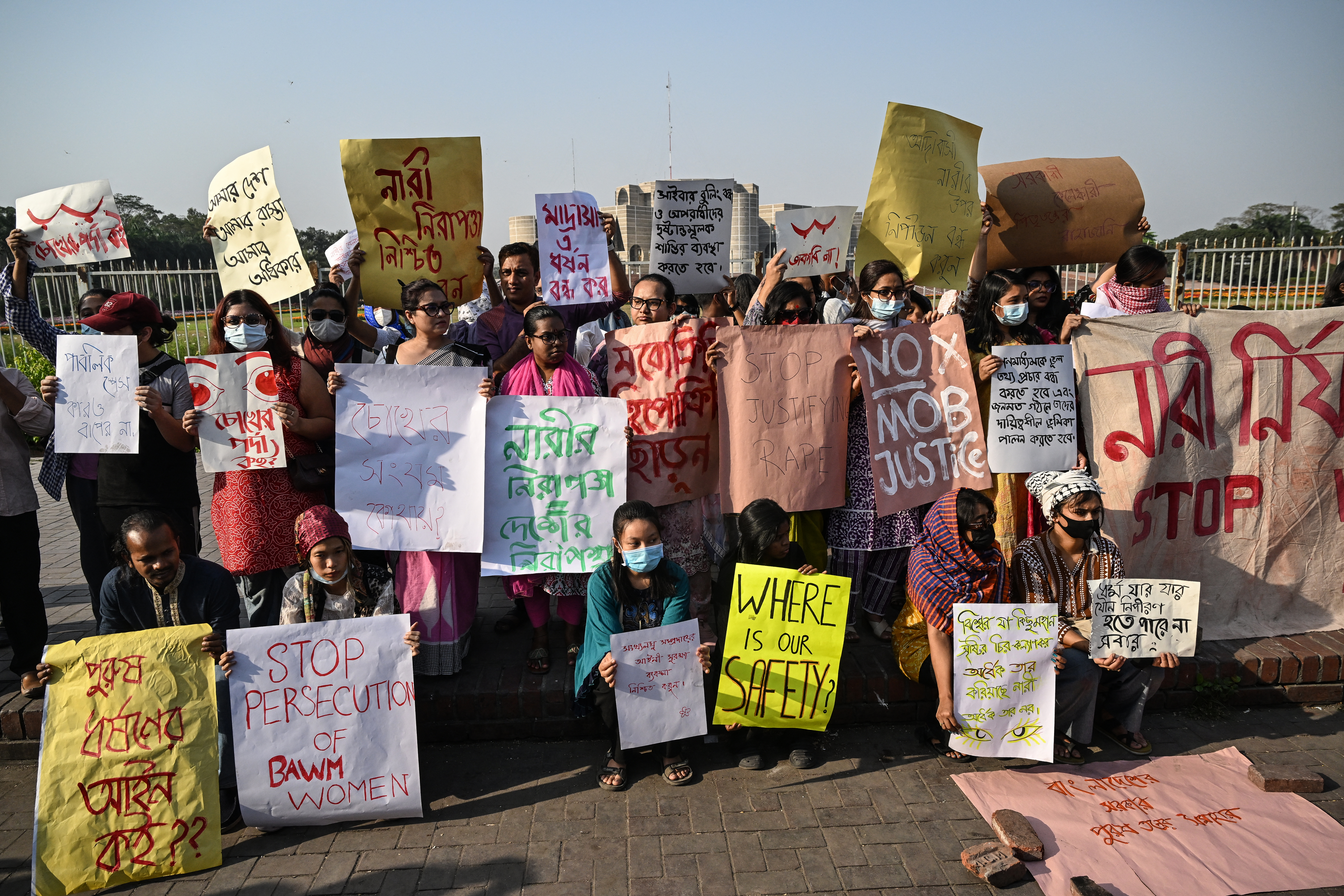 Women activists holding posters take part in a protest.