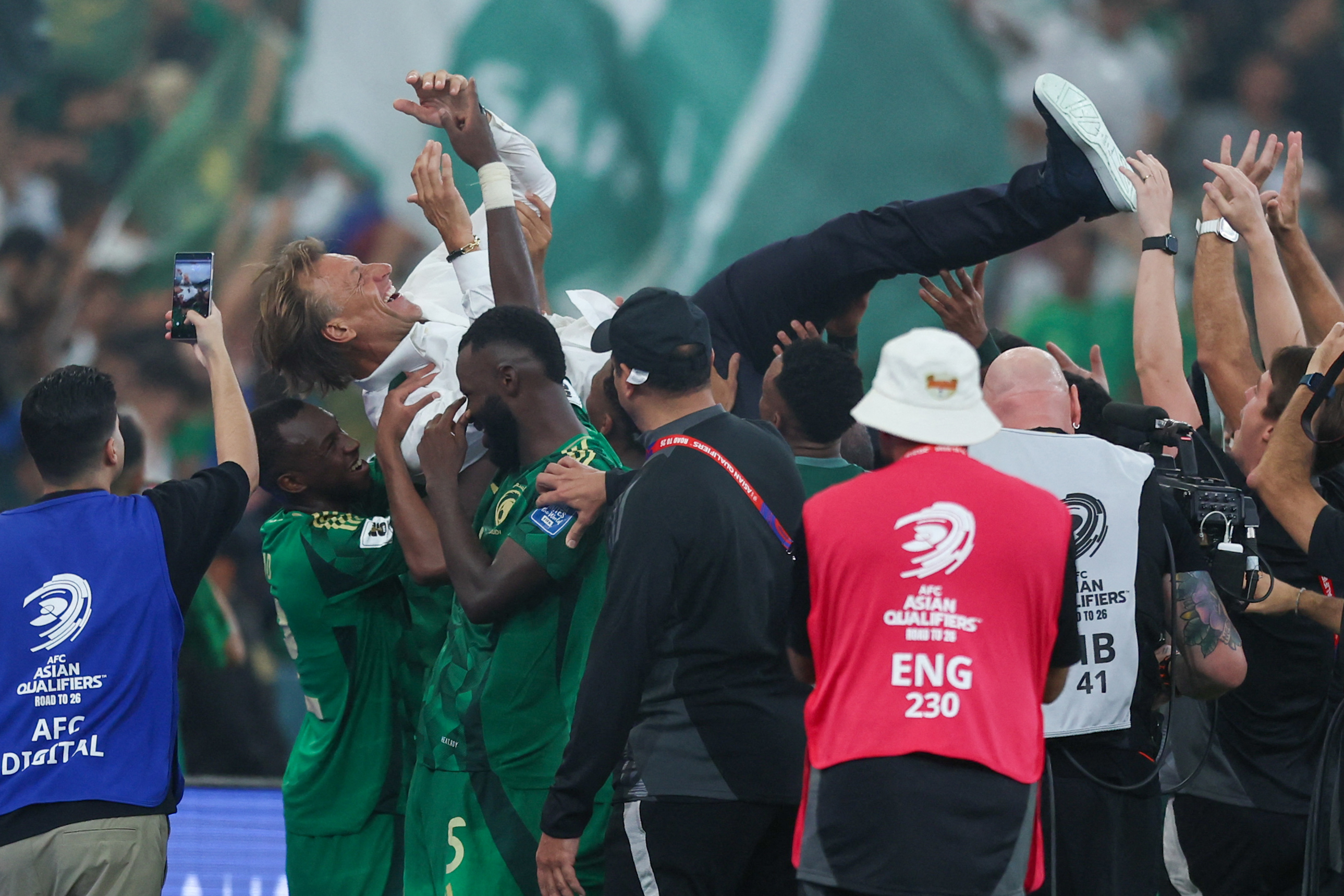 Saudi Arabia players celebrate with French coach Herve Renard during the FIFA World Cup 2026 Asian qualifier football match between Saudi Arabia and Iraq at King Abdullah Sports City in Jeddah on October 14, 2025. (Photo by Abdel Ghani BASHIR / AFP)