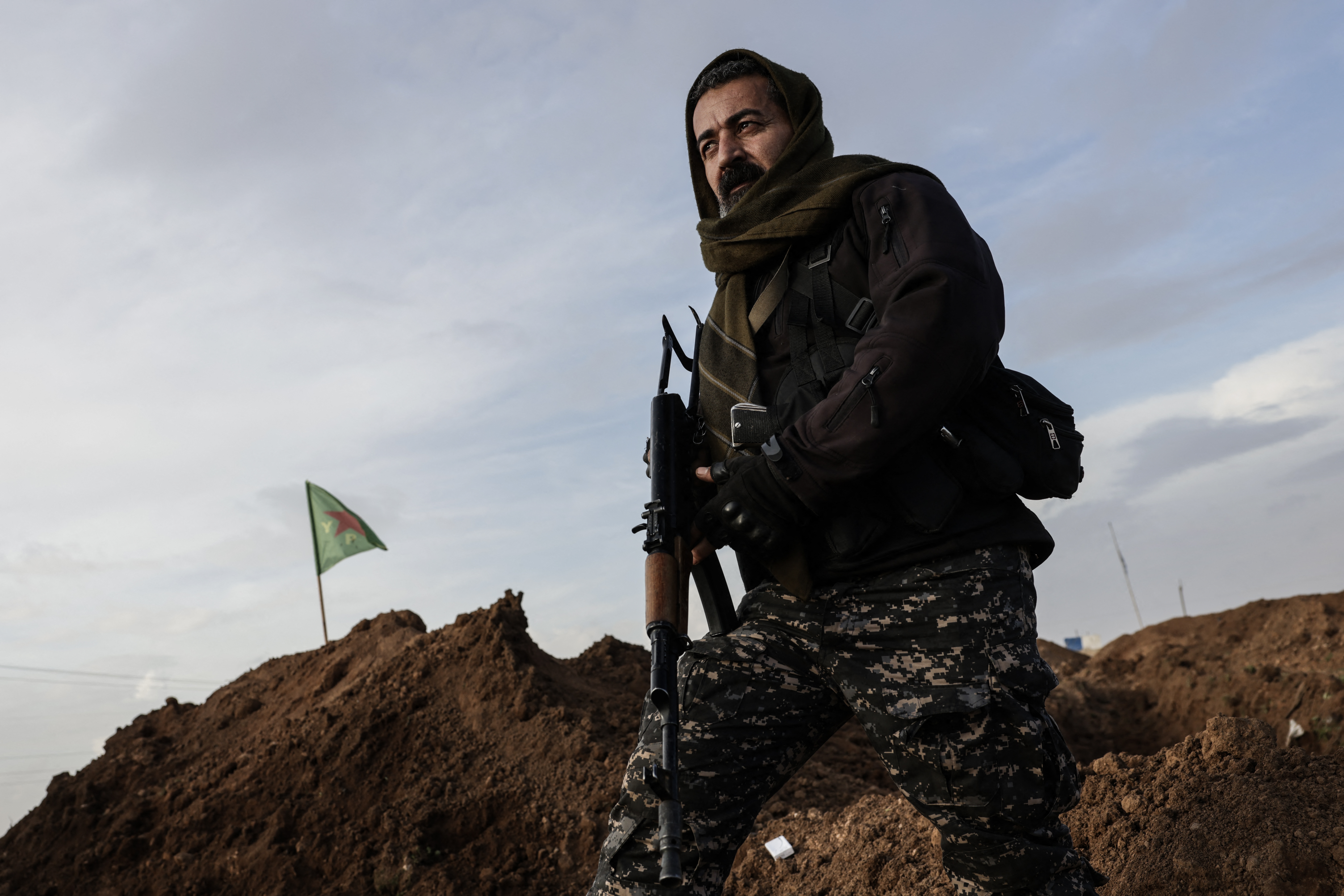 A member of the Syrian government forces stands on a mound of earth as security personnel enter the Kurdish-majority city of Qamishli on February 3, 2026. Syrian government forces started entering Qamishli on February 3, under an integration deal agreed with the Kurds last week, state media reported. The move comes after security personnel entered the mixed Kurdish-Arab city of Hasakeh and the countryside around the Kurdish town of Kobane a day earlier, as part of the comprehensive agreement to gradually integrate Kurdish forces and institutions into the state. [Bakr ALkasem / AFP]