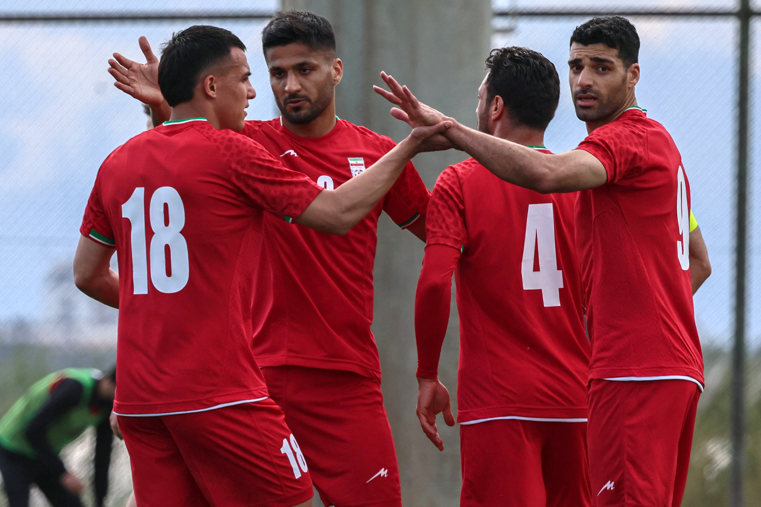 Iran's forward #18 Amirhossein Hosseinzadeh celebrates with his teammates after scoring a goal during a friendly football match between Iran and Costa Rica, in Antalya, southern Turkey, on March 31, 2026. FIFA's president told AFP that Iran "will be at the World Cup" despite the Middle East war. (Photo by Adem ALTAN / AFP)