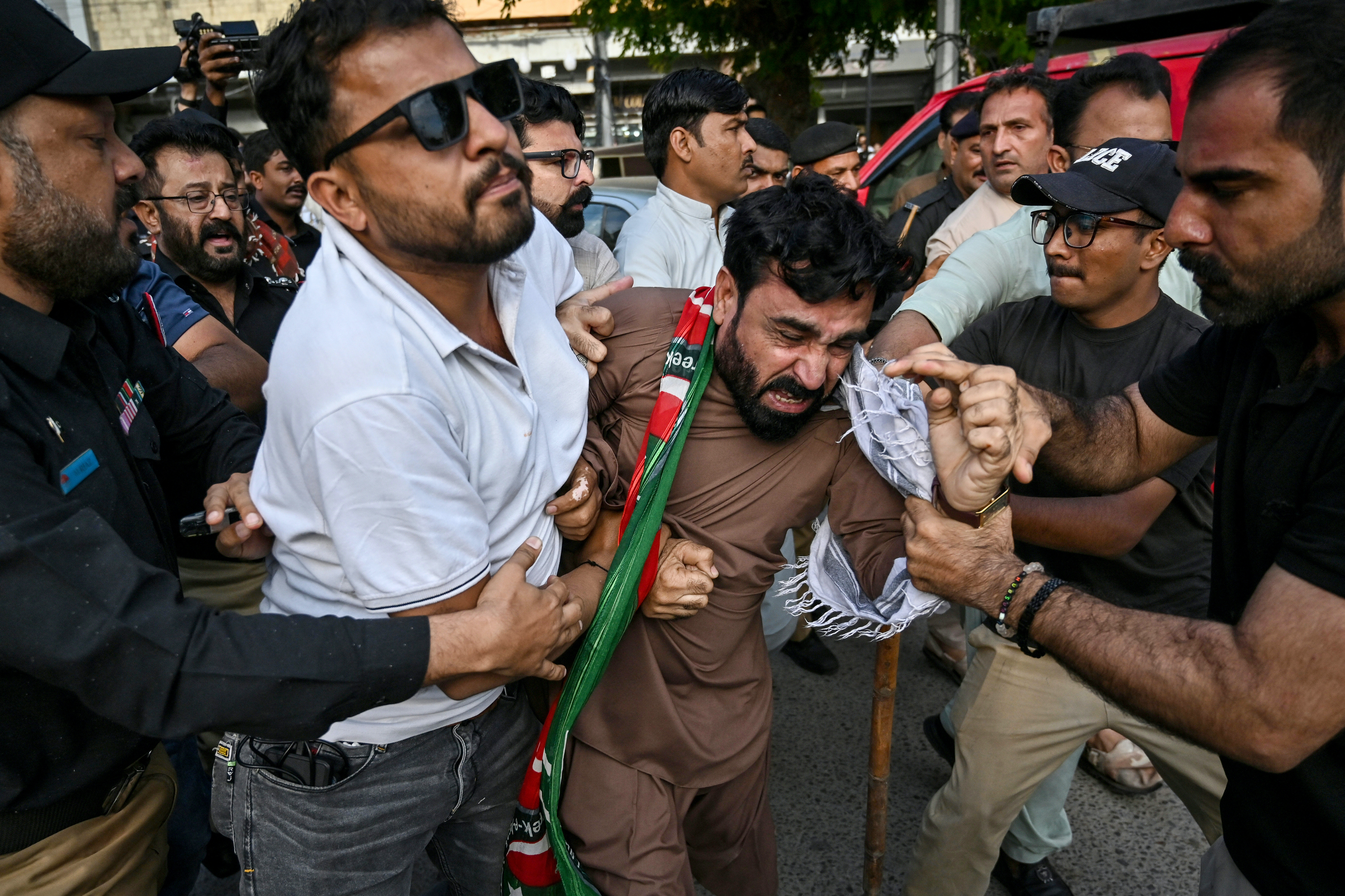 Police personnel detain protesters.