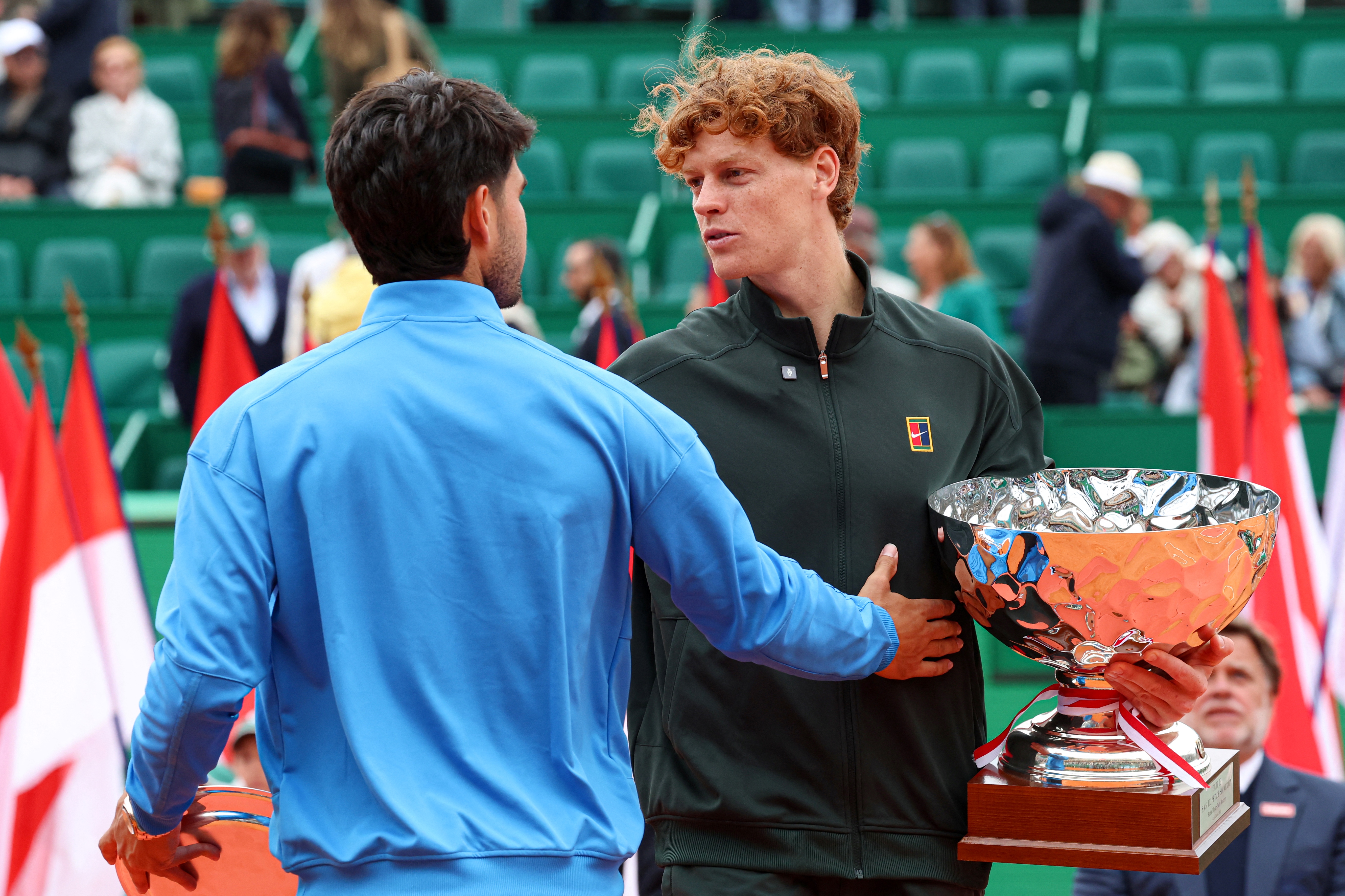 Italy's Jannik Sinner (R) embraces with Spain's Carlos Alcaraz after winning the Monte Carlo ATP Masters Series Tournament final tennis match on Court Rainier III at the Monte-Carlo Country Club in Roquebrune-Cap-Martin, south-eastern France on April 12, 2026. (Photo by Valery HACHE / AFP)