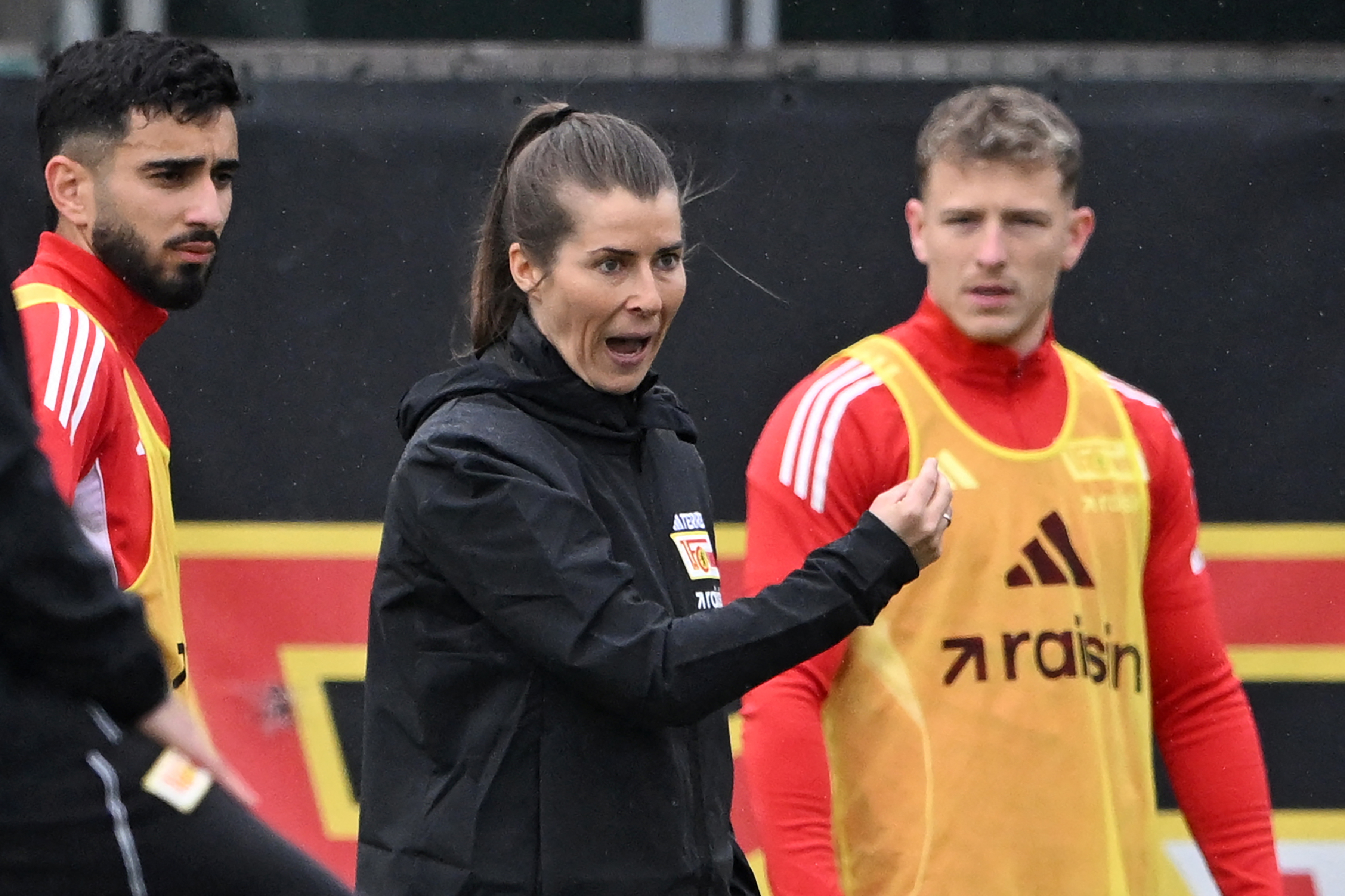 Union Berlin's new German head coach Marie-Louise Eta (C) gestures as she speaks with players during a training session of German first division Bundesliga football club 1 FC Union Berlin in Berlin on April 14, 2026. Bundesliga club Union Berlin named Marie-Louise Eta as head coach, making her the first female manager of a men's team in a top-five European league, after former mentor Steffen Baumgart was sacked. The 34-year-old will take over for the remainder of the season. (Photo by RALF HIRSCHBERGER / AFP)