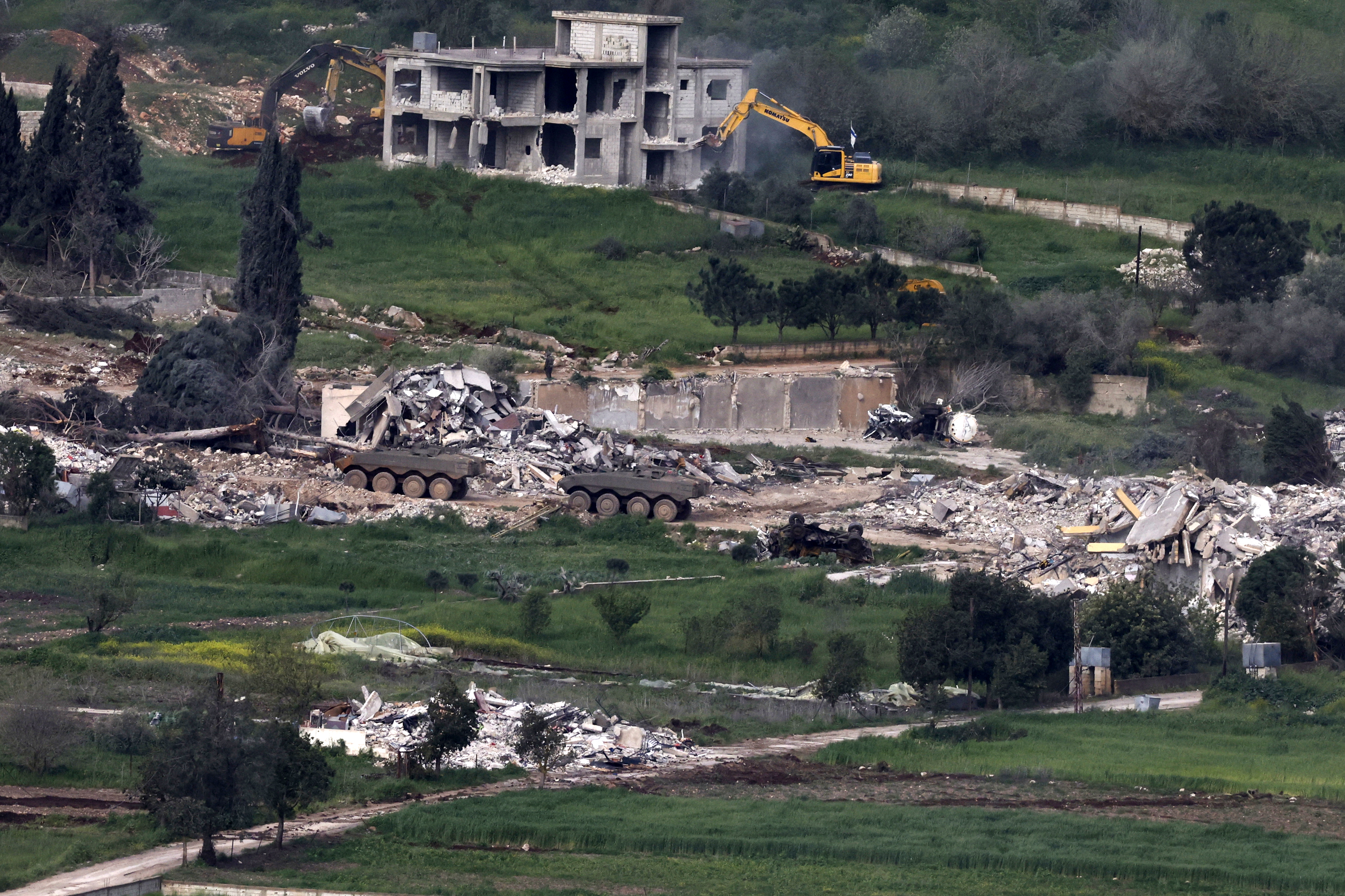 Israeli army armoured vehicles and excavators demolishing houses in the southern Lebanese village of Mais al-Jabal