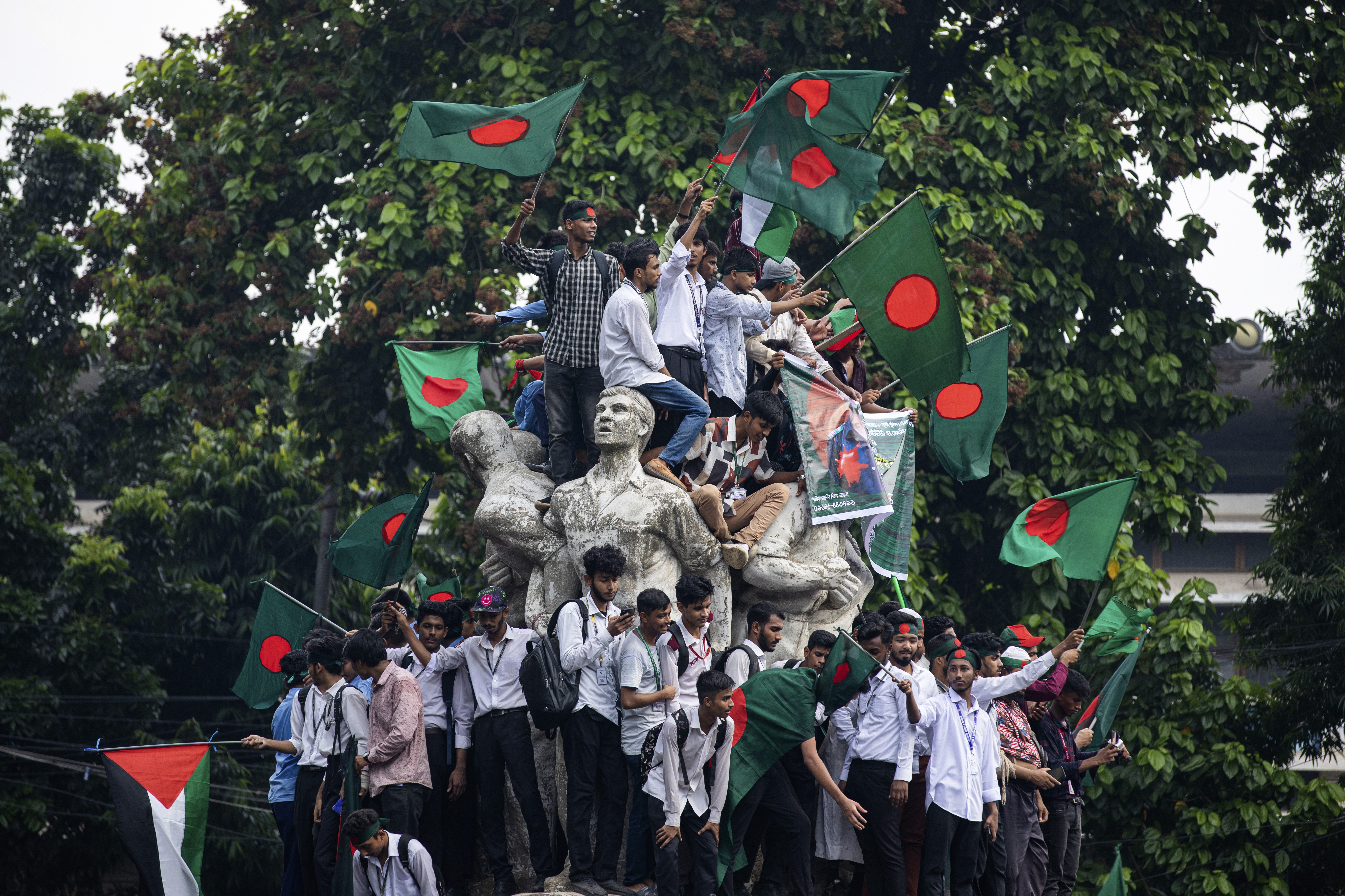 Students and other activists carry Bangladesh's national flag during a protest march organized by Students