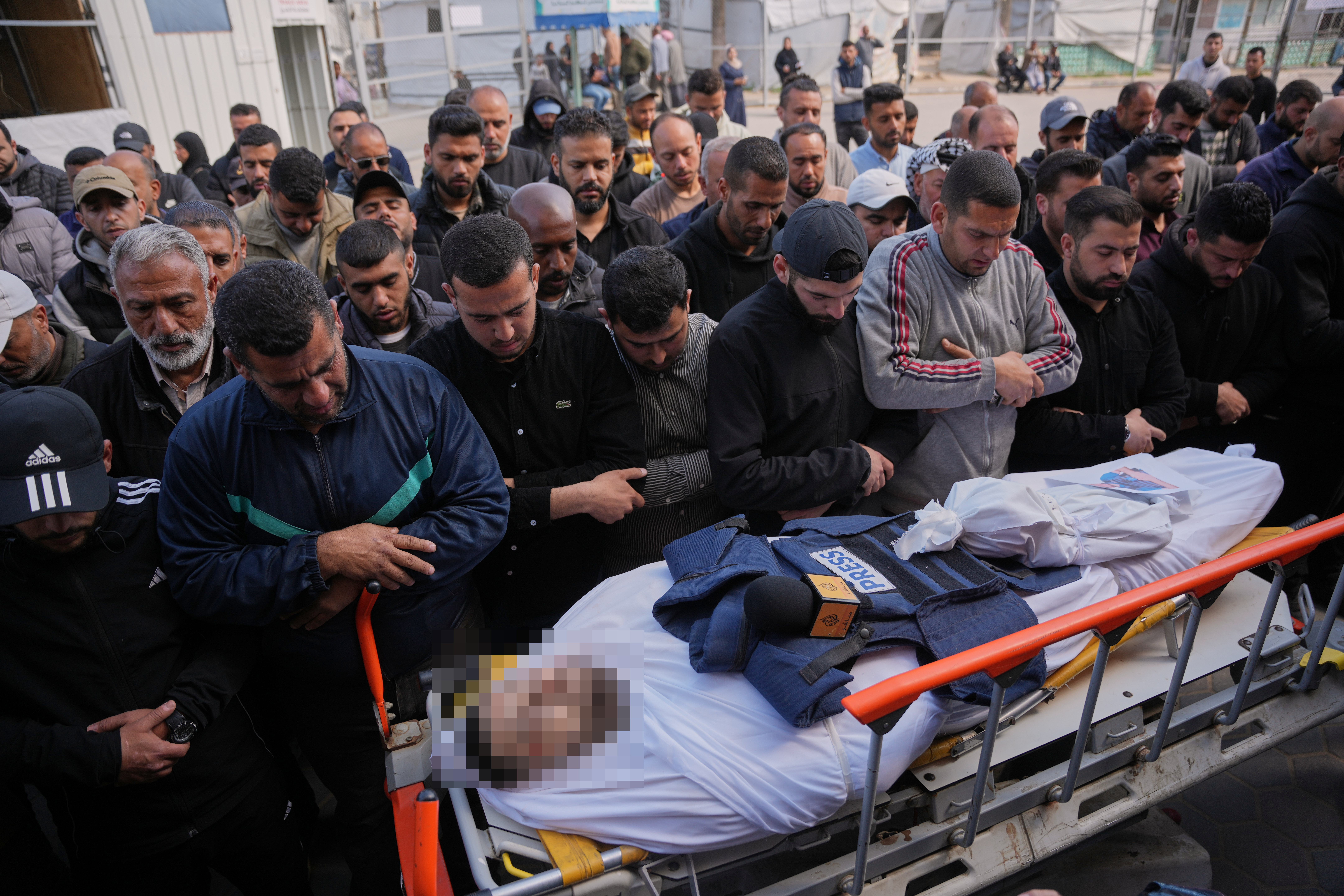 Palestinians pray over the body of Al Jazeera correspondent