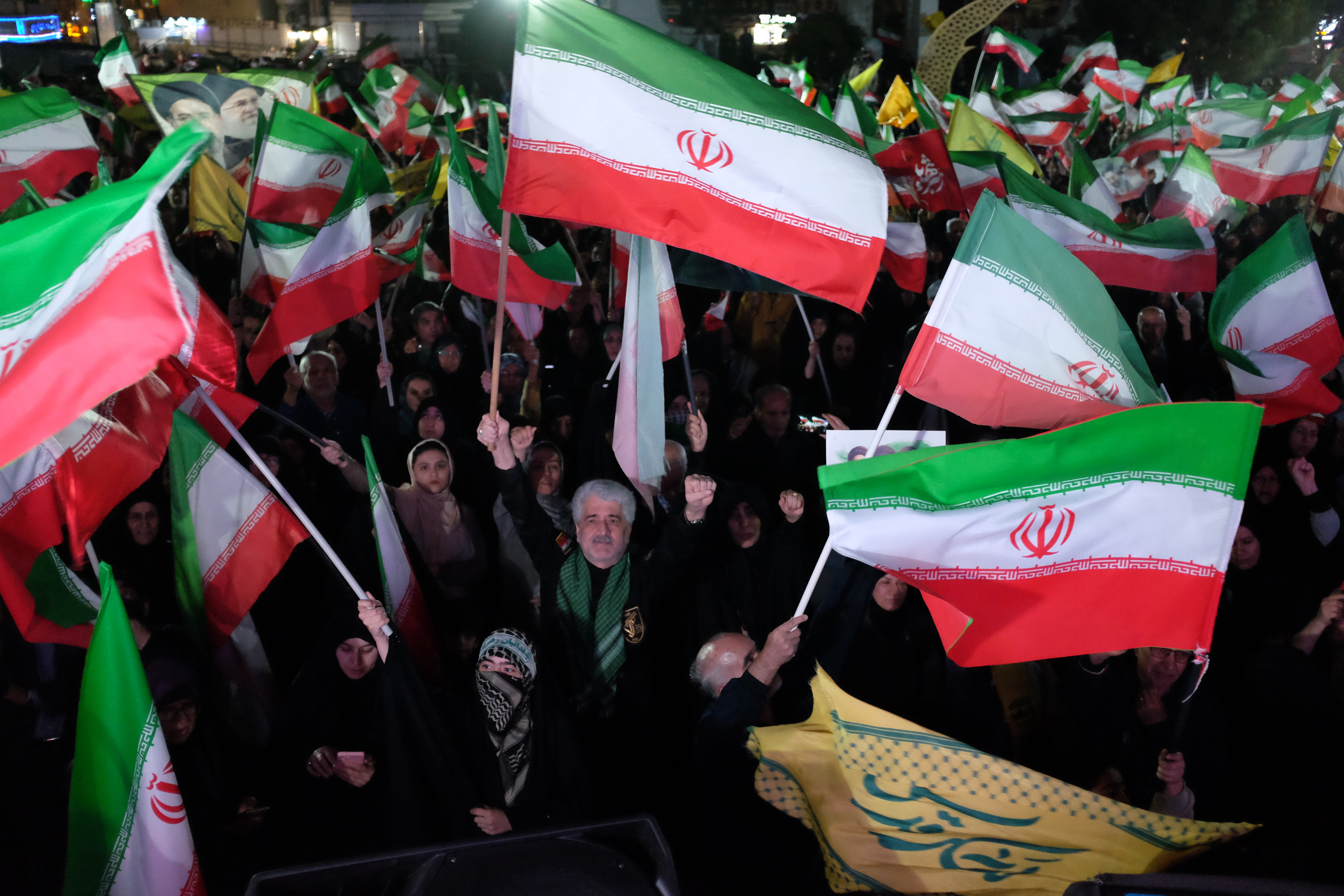 Pro-government demonstrators wave Iranian flags during a gathering in Tehran, Iran on April 11, 2026.