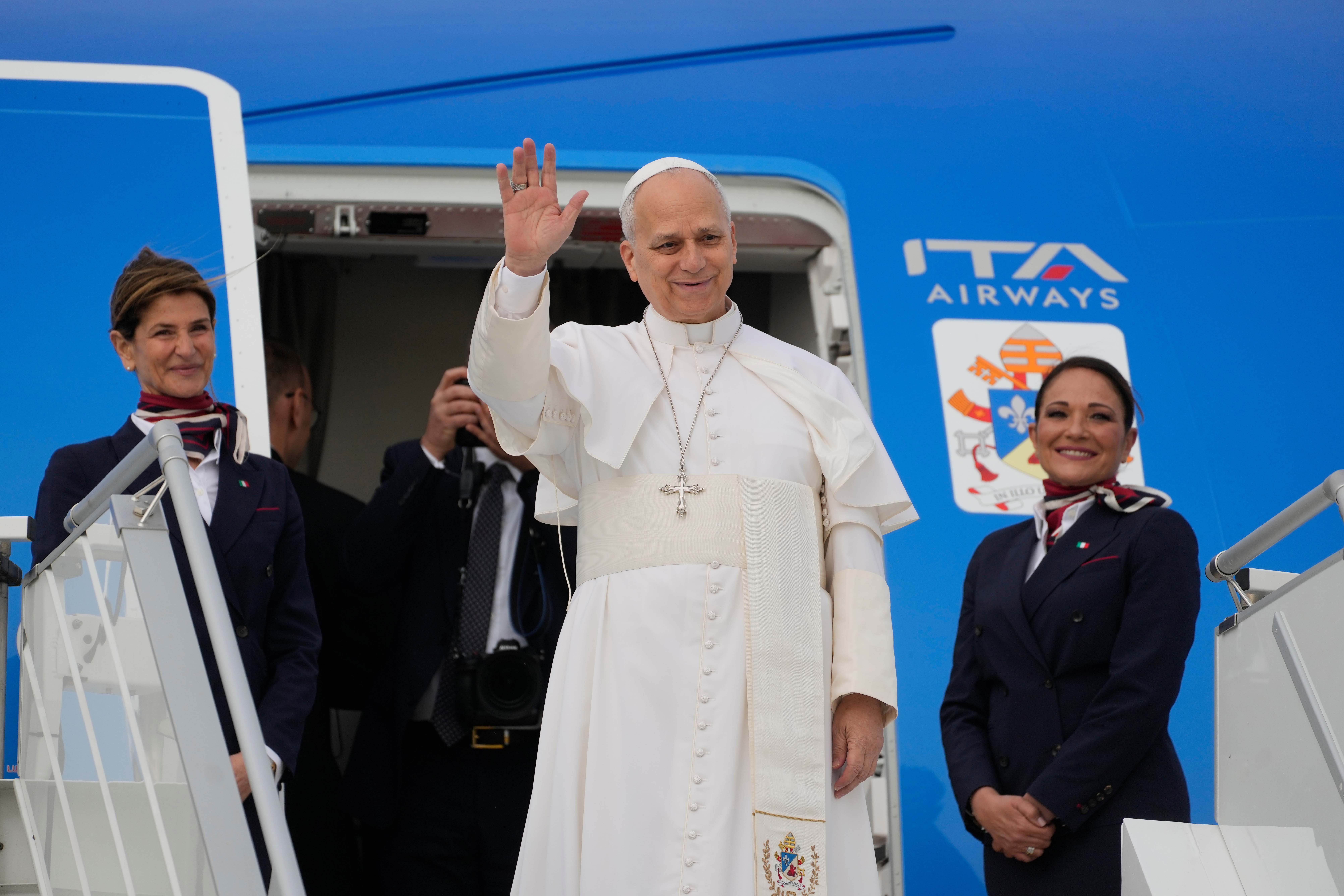 Pope Leo XIV waves before boarding a flight