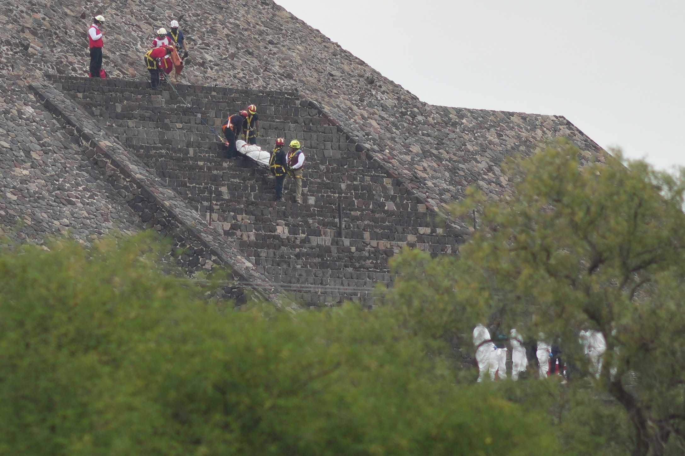 Forensic workers carry the body of a victim down a pyramid after authorities said a gunman opened fire, in Teotihuacan, Mexico, Monday, April 20, 2026. (AP Photo/Eduardo Verdugo)