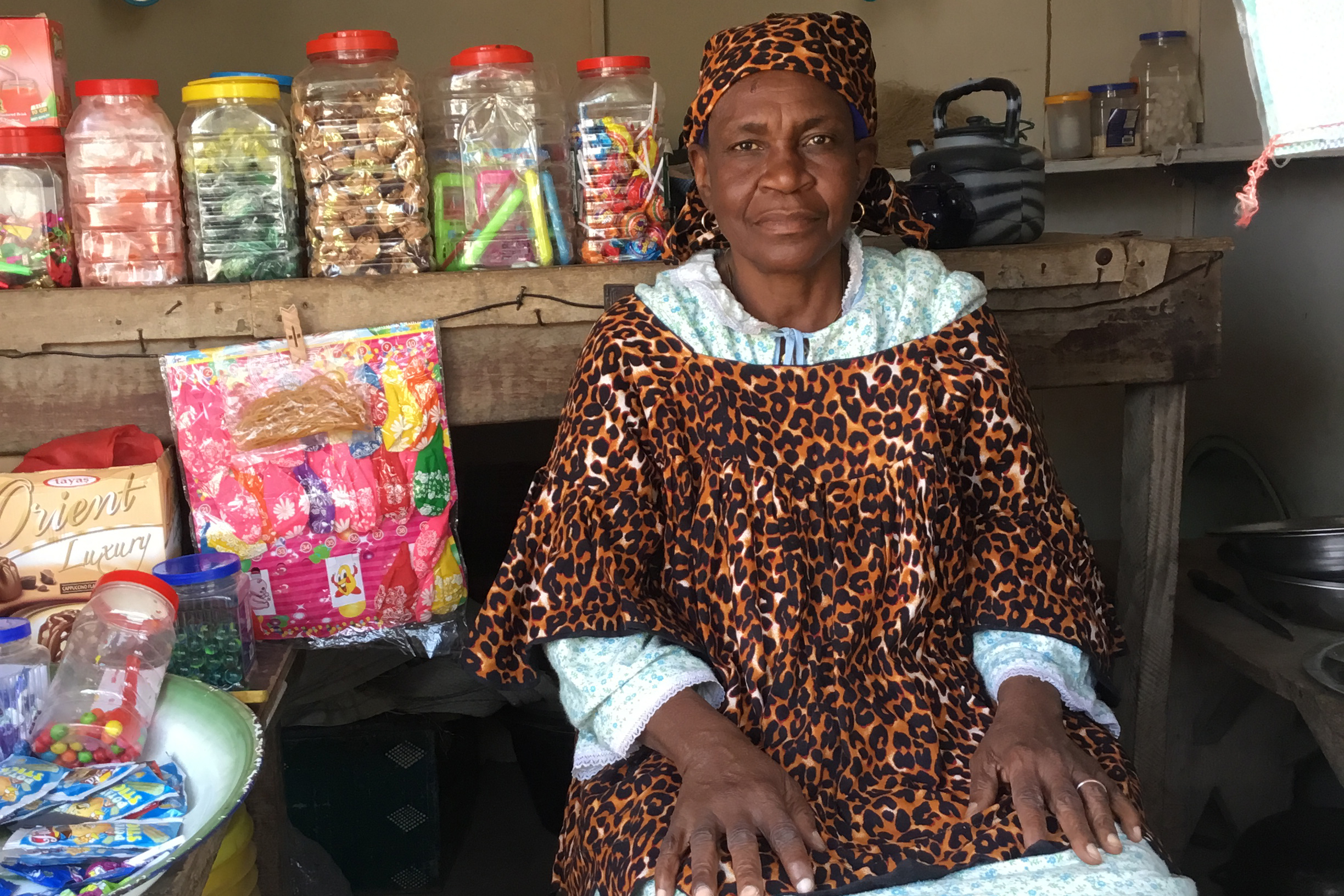 Amina, 64, sits inside her small shop, where she sells cooking ingredients and children’s clothing. Without the required documentation, she is unable to formally register the.