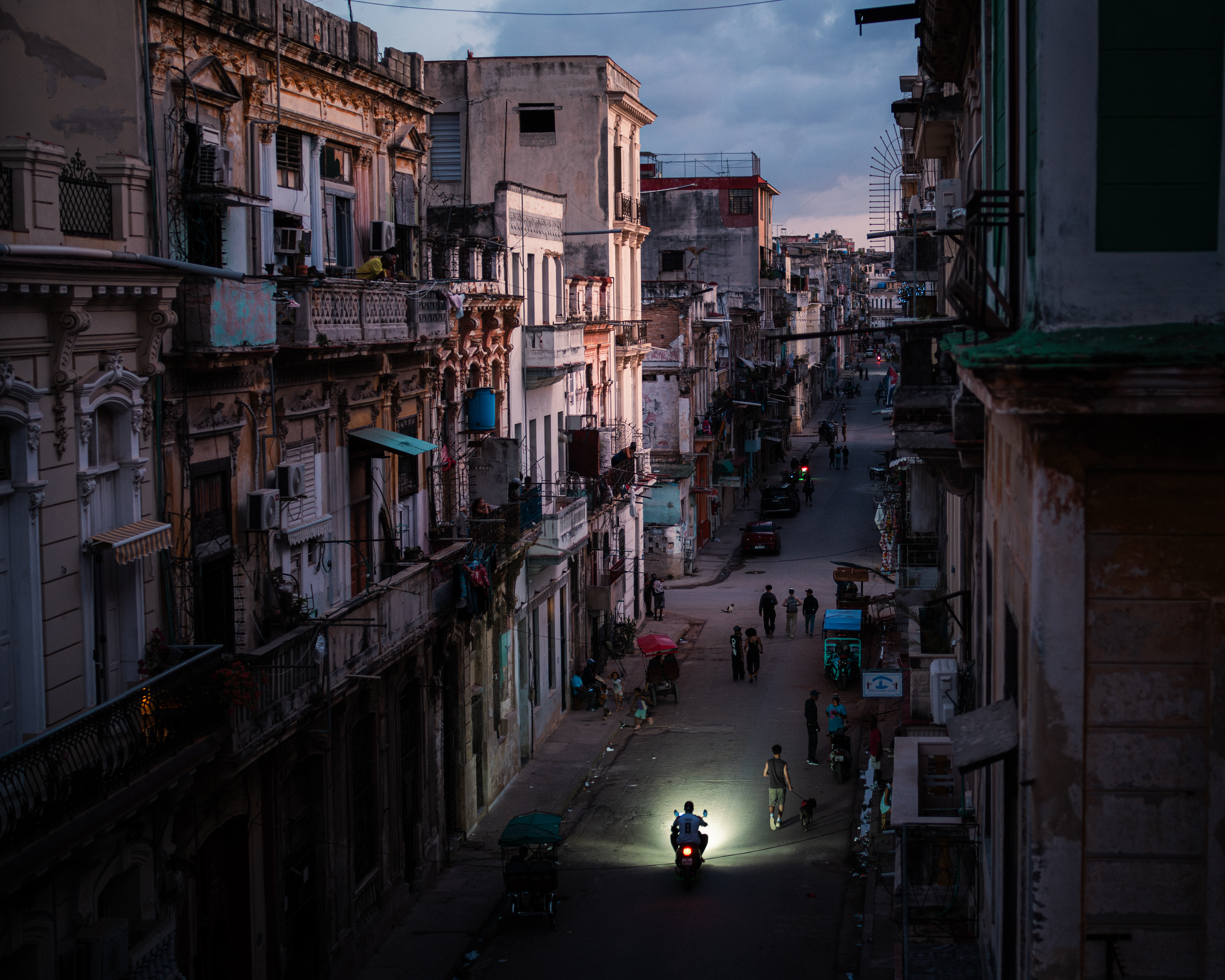 On March 21st, during a nationwide blackout, residents hurry through the streets as the sun goes down over a city without light. [Euan Wallace/ Al Jazeera]