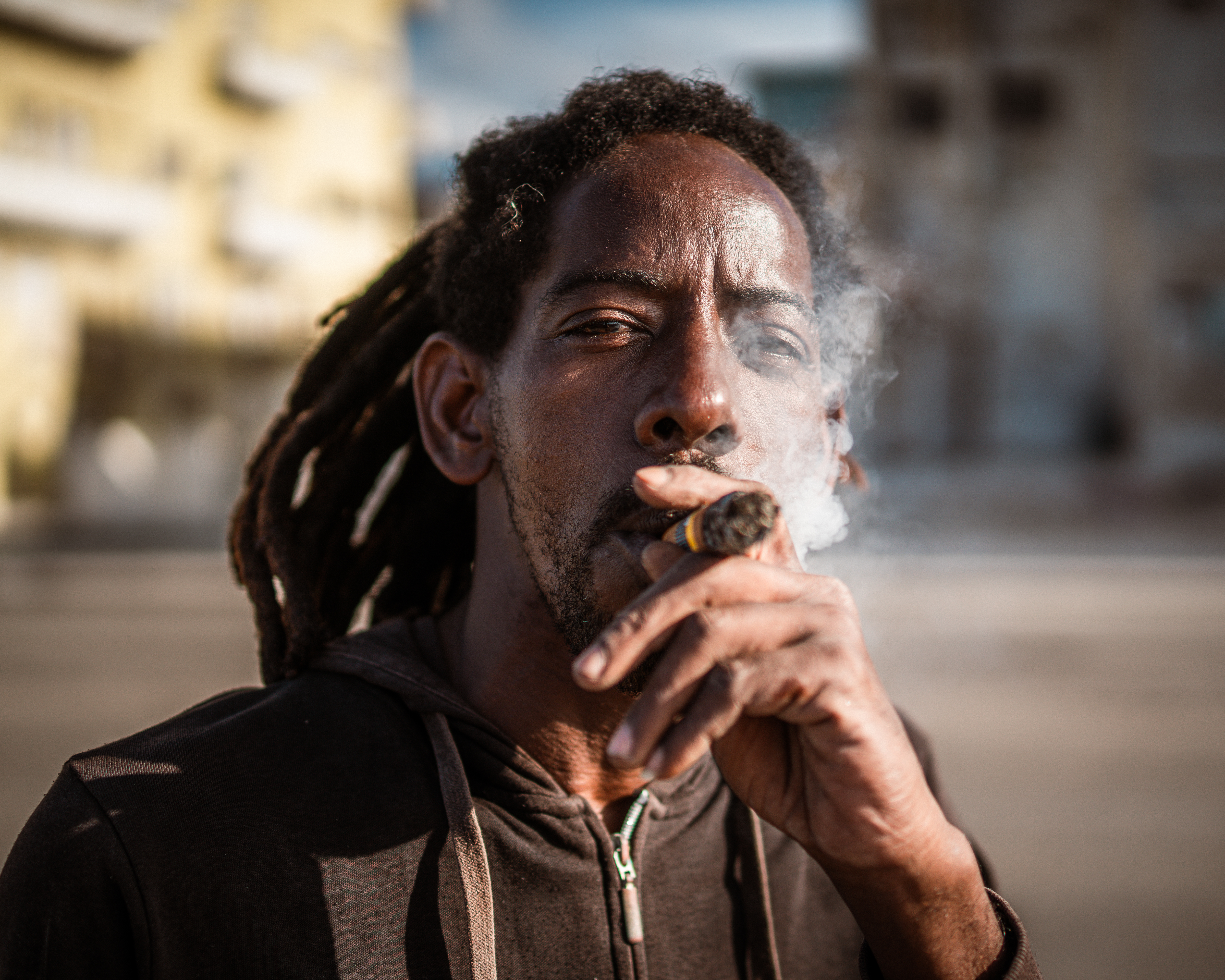 A Havana local smokes a cigar on the Malecón - the city’s waterfront area. Both domestically and abroad, Cuban cigars are becoming an increasingly rare luxury. [Euan Wallace/ Al Jazeera]