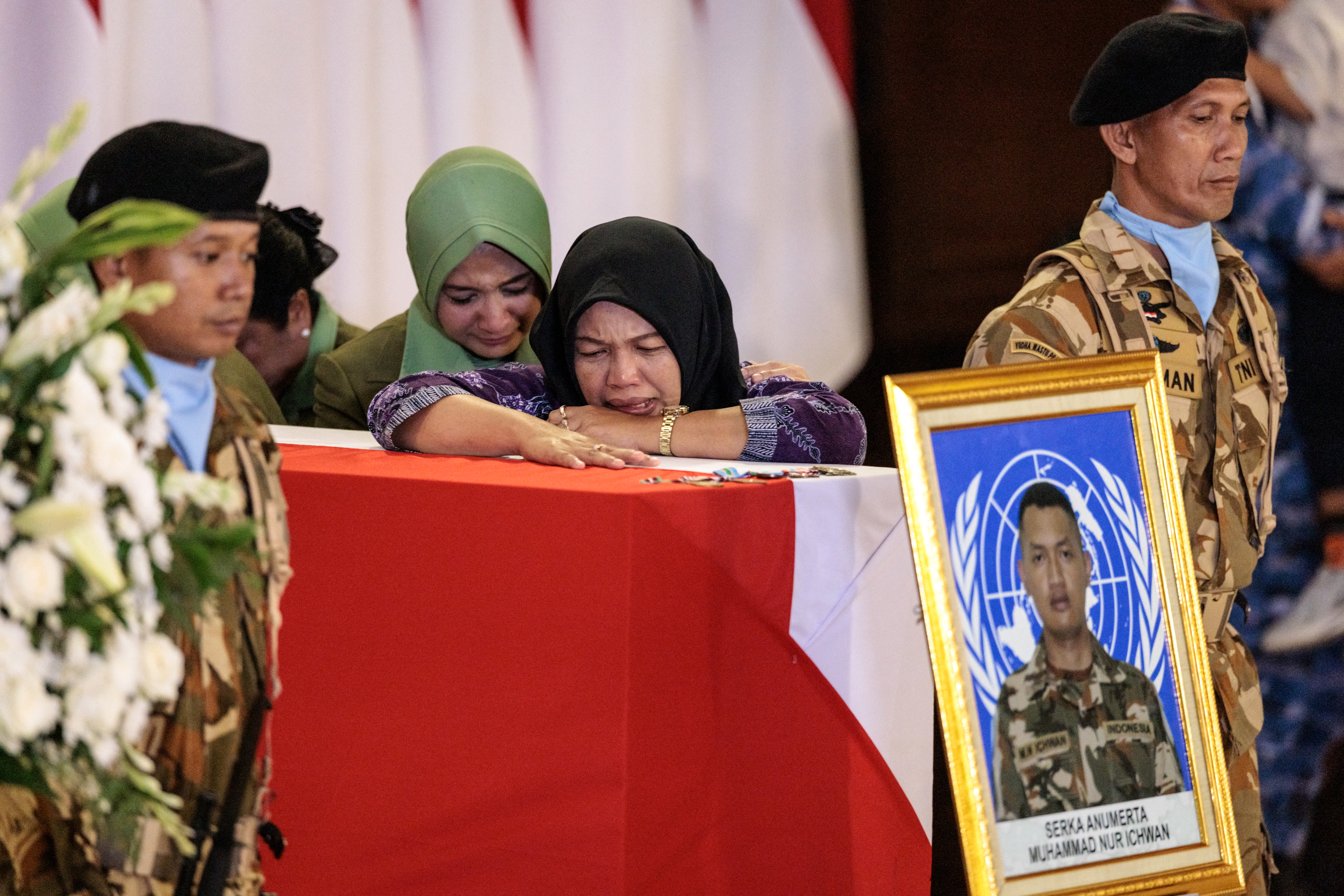 TOPSHOT - Family members of Indonesian soldier who was killed while serving with the United Nations Interim Force in Lebanon (UNIFIL) in southern Lebanon, mourn beside his coffin as the coffins of three Indonesian soldiers arrive at Soekarno-Hatta International Airport in Tangerang on April 4, 2026.