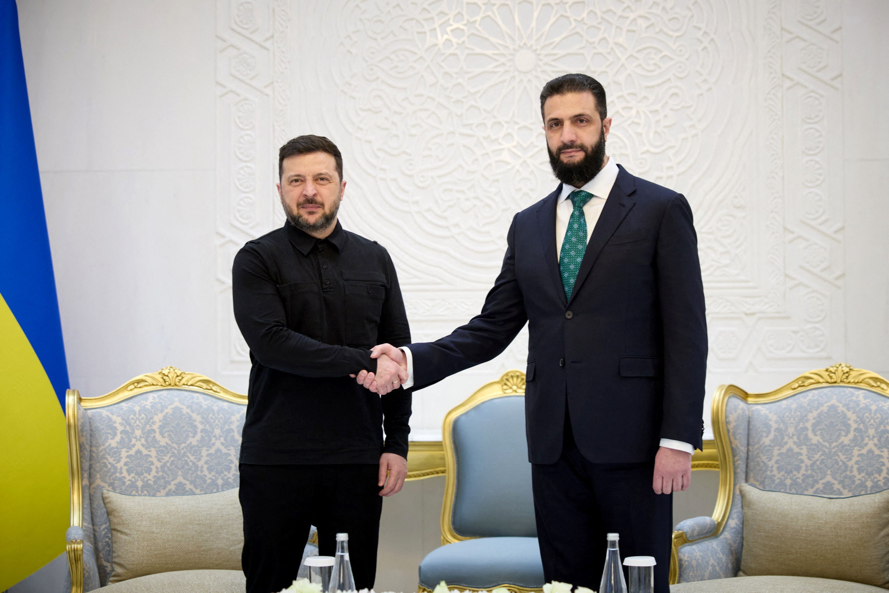This handout photograph taken and released by the Ukrainian Presidential Press Service on April 5, 2026 shows Ukraine's President Volodymyr Zelensky (L) and Syrian President Ahmed al-Sharaa shaking hands during their meeting in Damascus.