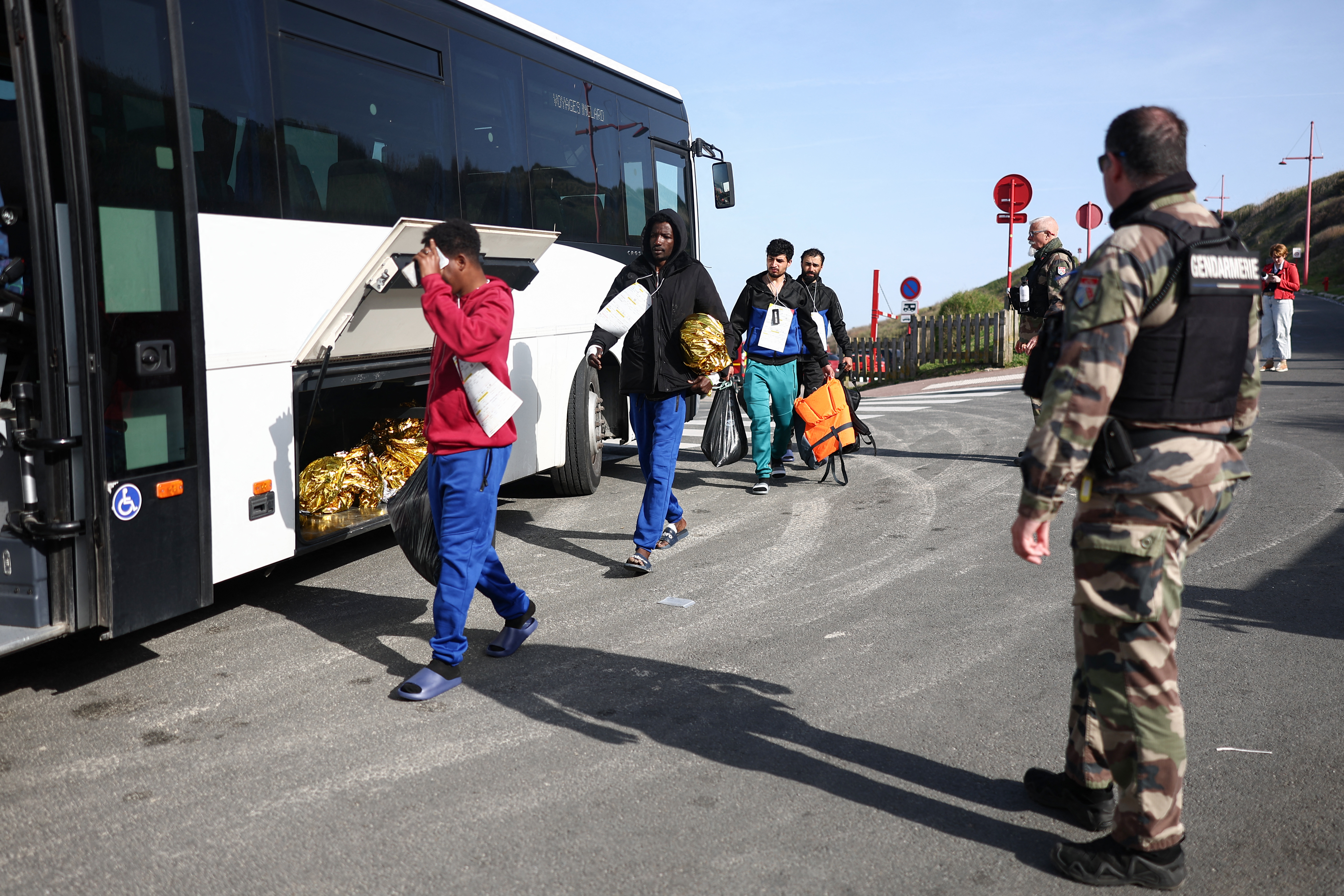 People board a bus to a reception and accommodation centre.