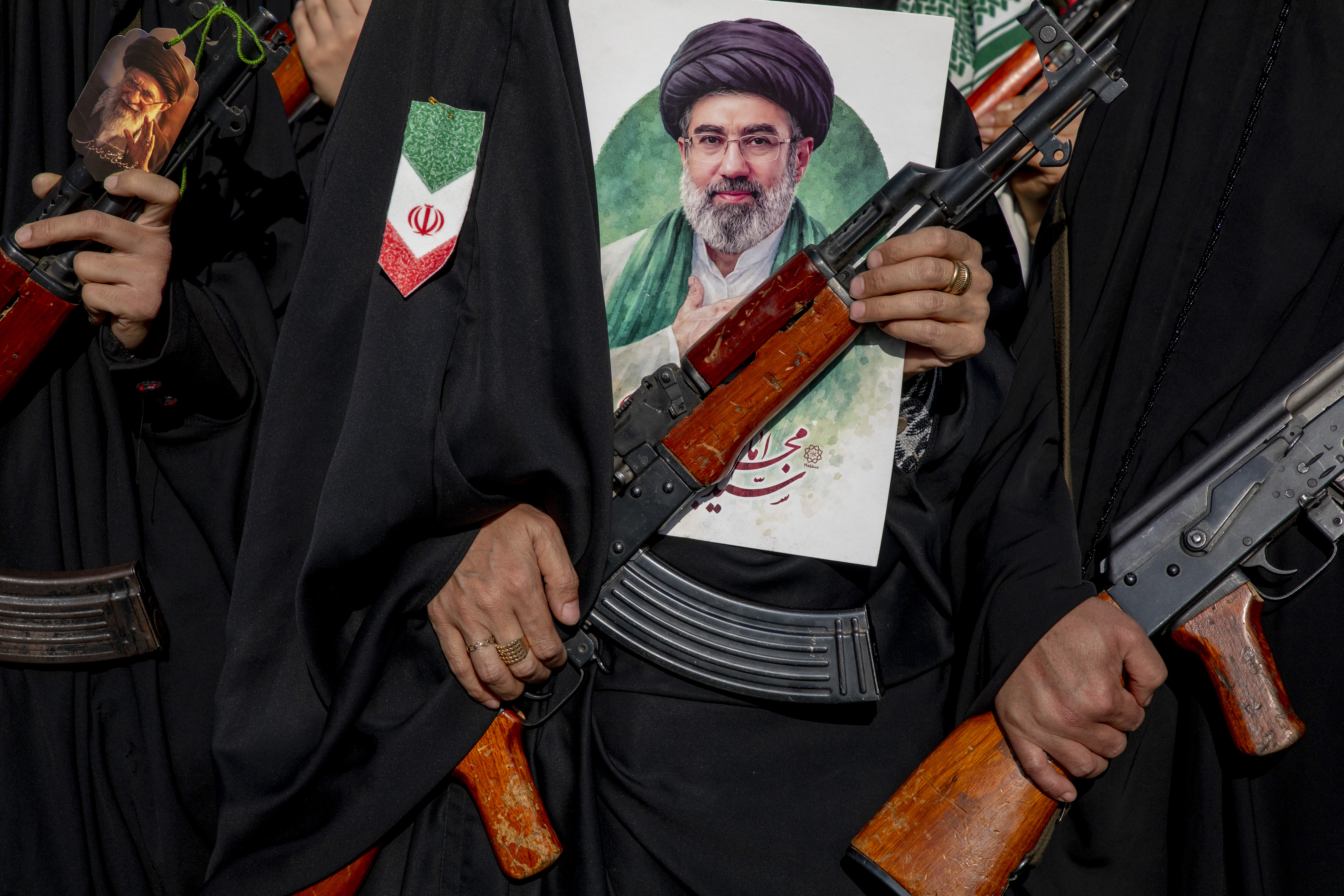 Women carry rifles and hold a picture of new Supreme Leader Mojtaba Khamenei during a pro-government demonstration in April 2026