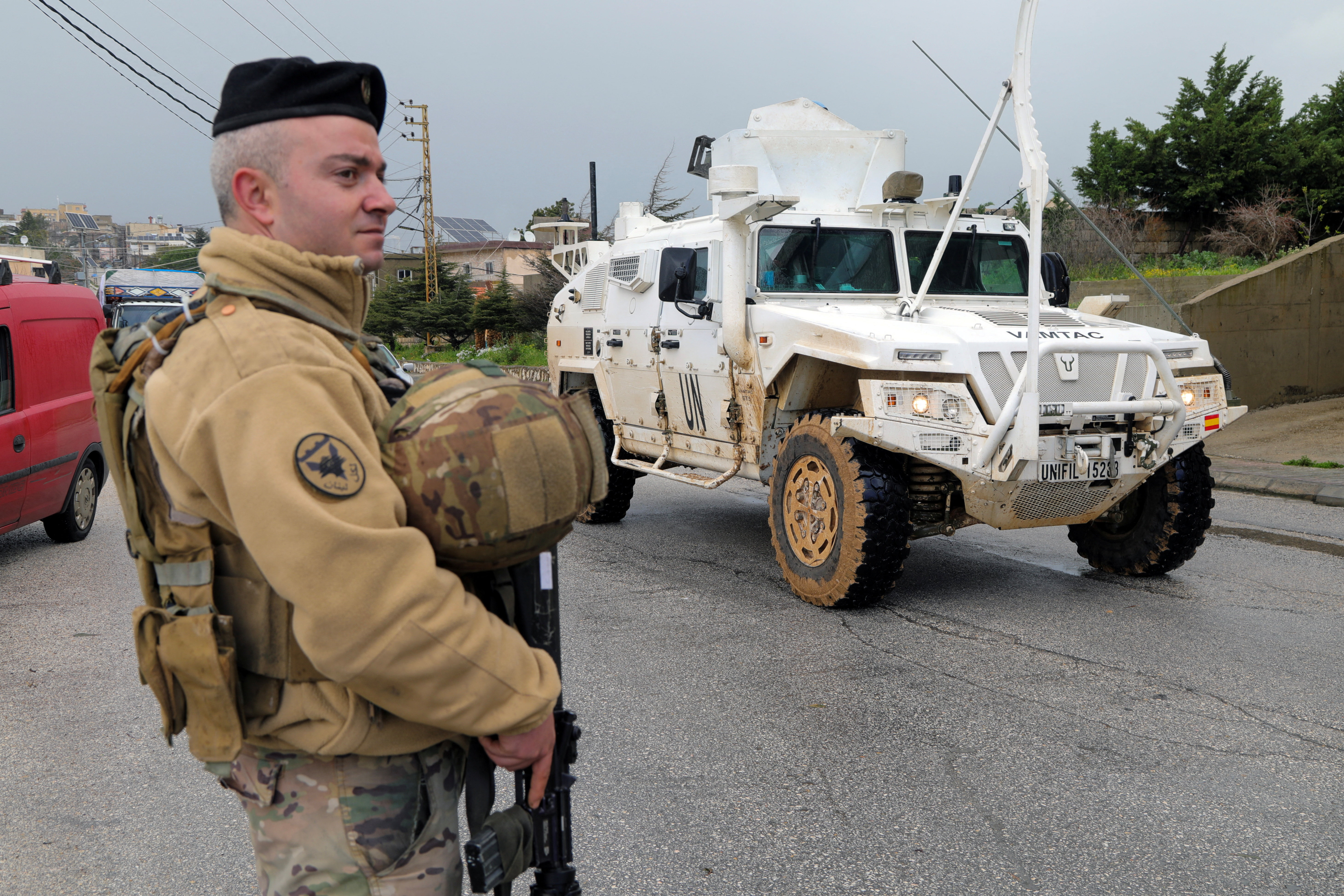A UNIFIL vehicle drives past a Lebanese soldier, amid escalating hostilities between Israel and Hezbollah, as the U.S.-Israel conflict with Iran continues, in Qlayaa, southern Lebanon, March 27, 2026. REUTERS/Karamallah Daher