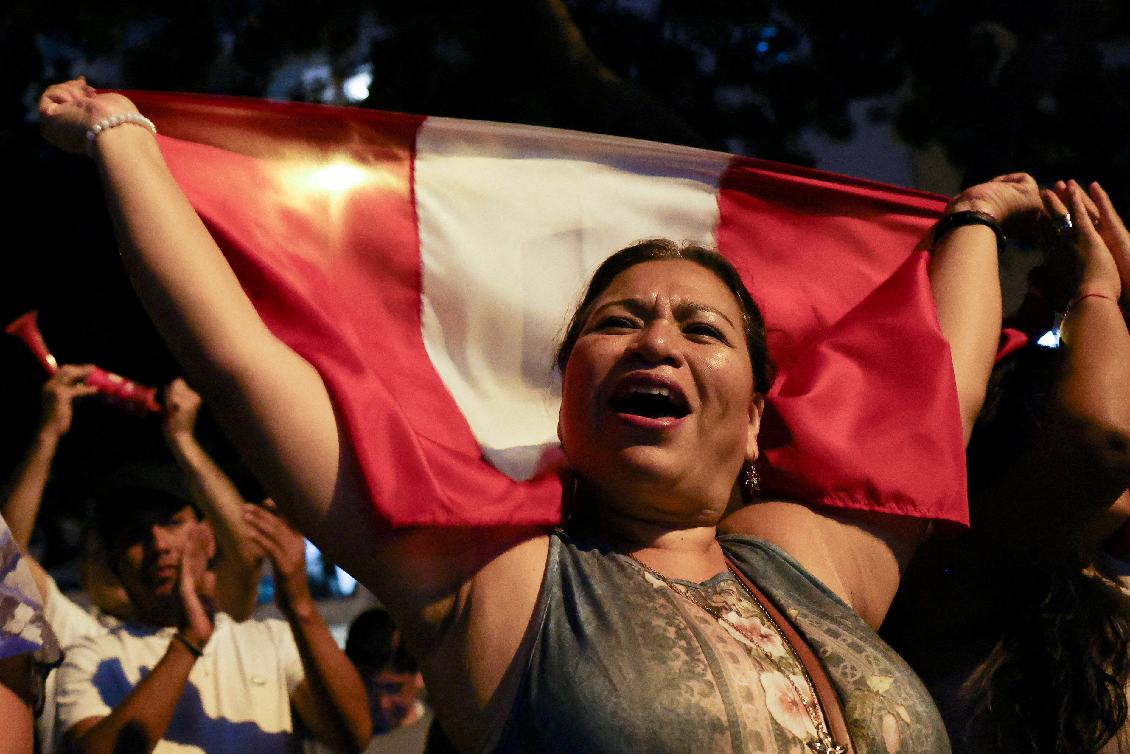 A protester displays a Peruvian flag as demonstrators gather outside Peru's electoral headquarters amid concerns about the voting process during the country's general election, in Lima, Peru, April 14, 2026. REUTERS/Manuel Orbegozo REFILE - REMOVING EXTRANEOUS WORD TPX IMAGES OF THE DAY