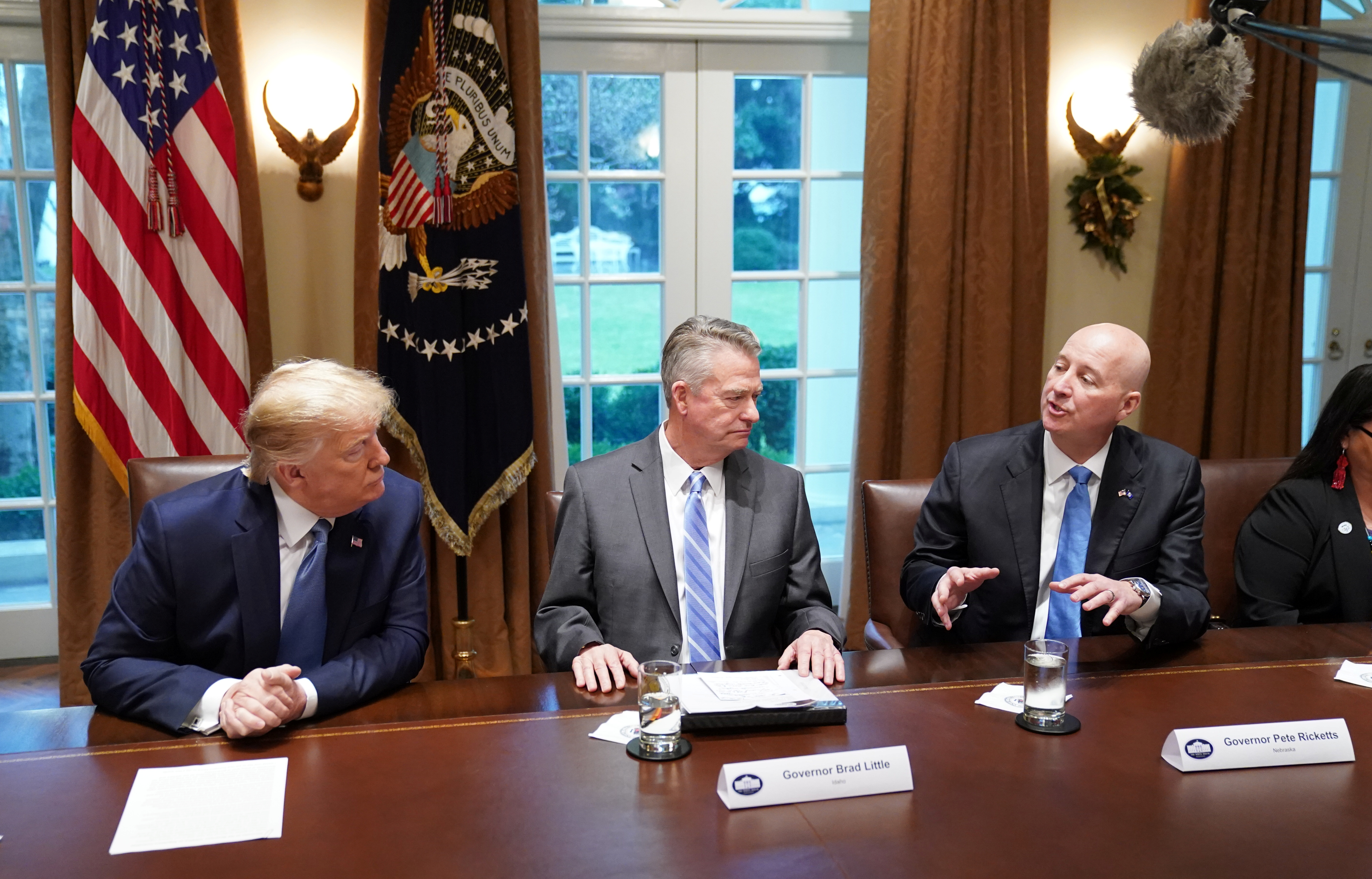 U.S. President Donald Trump listens to Nebraska Governor Pete Ricketts speak as Idaho Governor Brad Little sits between them during a roundtable on deregulation in the cabinet room at the White House in Washington, U.S., December 16, 2019. REUTERS/Kevin Lamarque