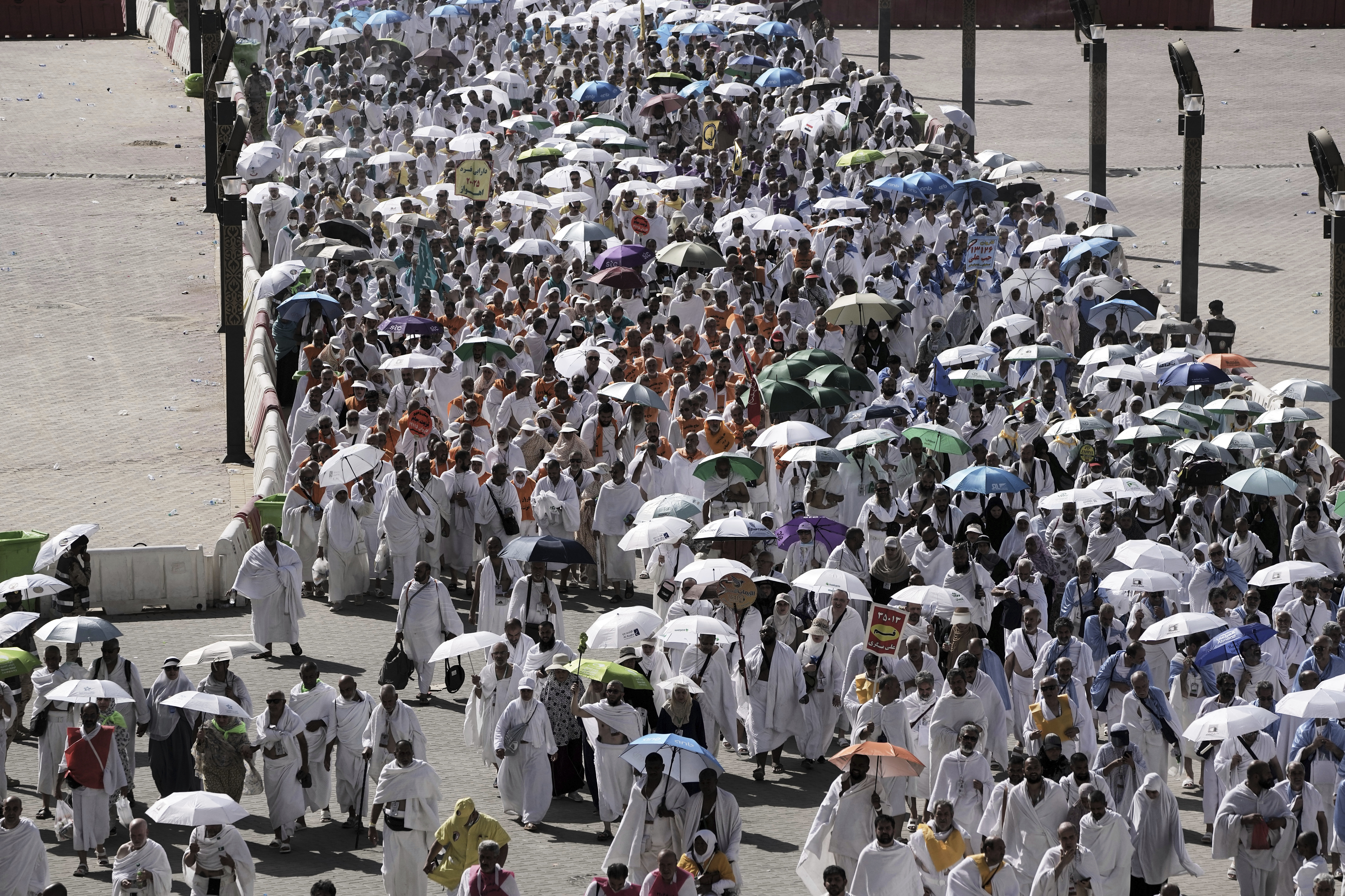 Muslim pilgrims walk on their way to cast stones at pillars in the symbolic stoning of the devil, the last rite of the annual Hajj, in Mina near the holy city of Mecca, Saudi Arabia, Friday, June 6, 2025. (AP Photo/Amr Nabil)