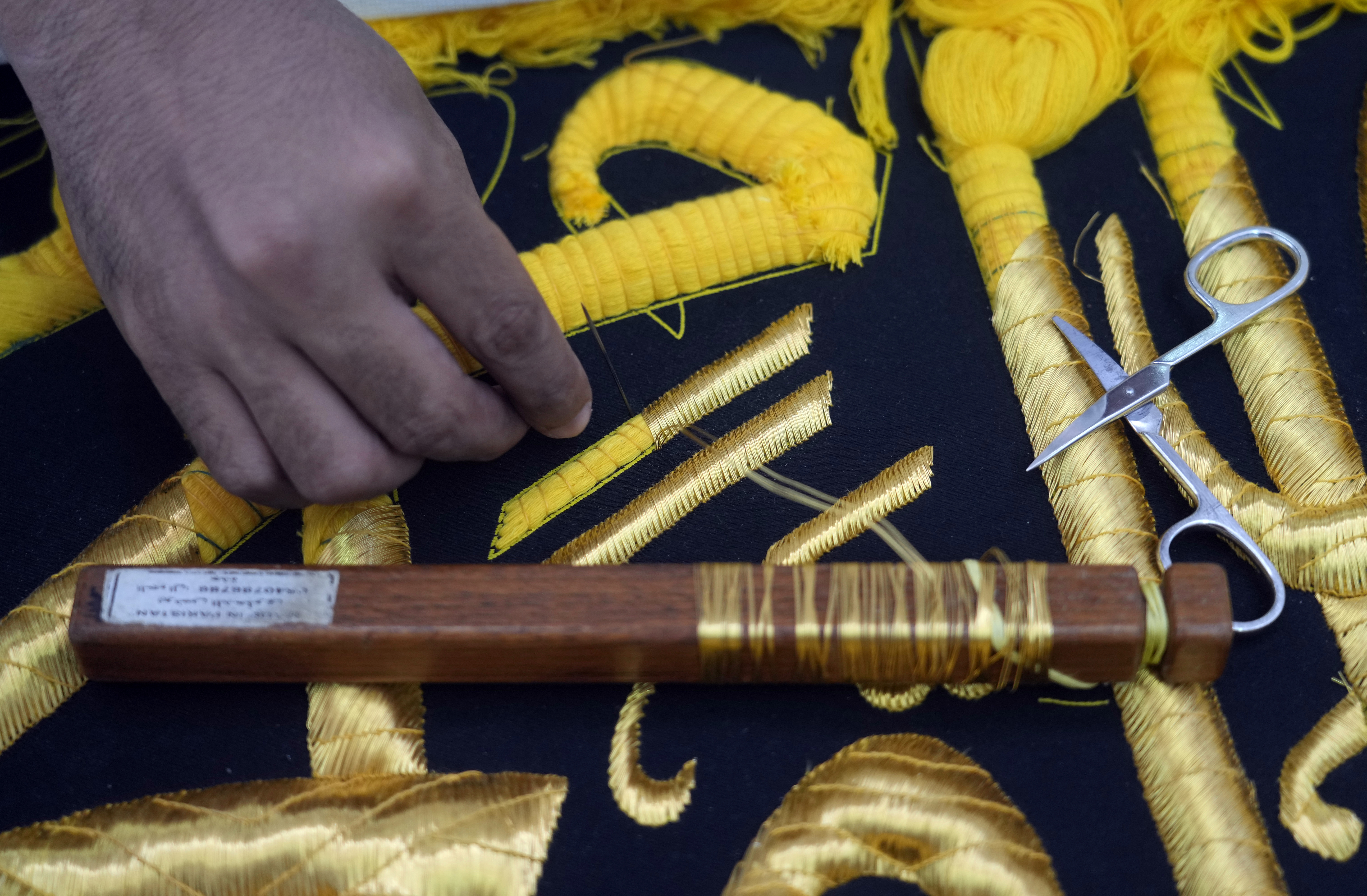 A Saudi worker embroiders Islamic calligraphy using gold-plated silver thread during the final stages in the preparation of a drape, or Kiswa, that covers the Kaaba, a cube-shaped structure at the heart the Grand Mosque, at the Kiswa factory in Mecca, Saudi Arabia, Wednesday, July 6, 2022. Muslim pilgrims are converging on Saudi Arabia's holy city of Mecca for the largest hajj since the coronavirus pandemic severely curtailed access to one of Islam's five pillars. (AP Photo/Amr Nabil)