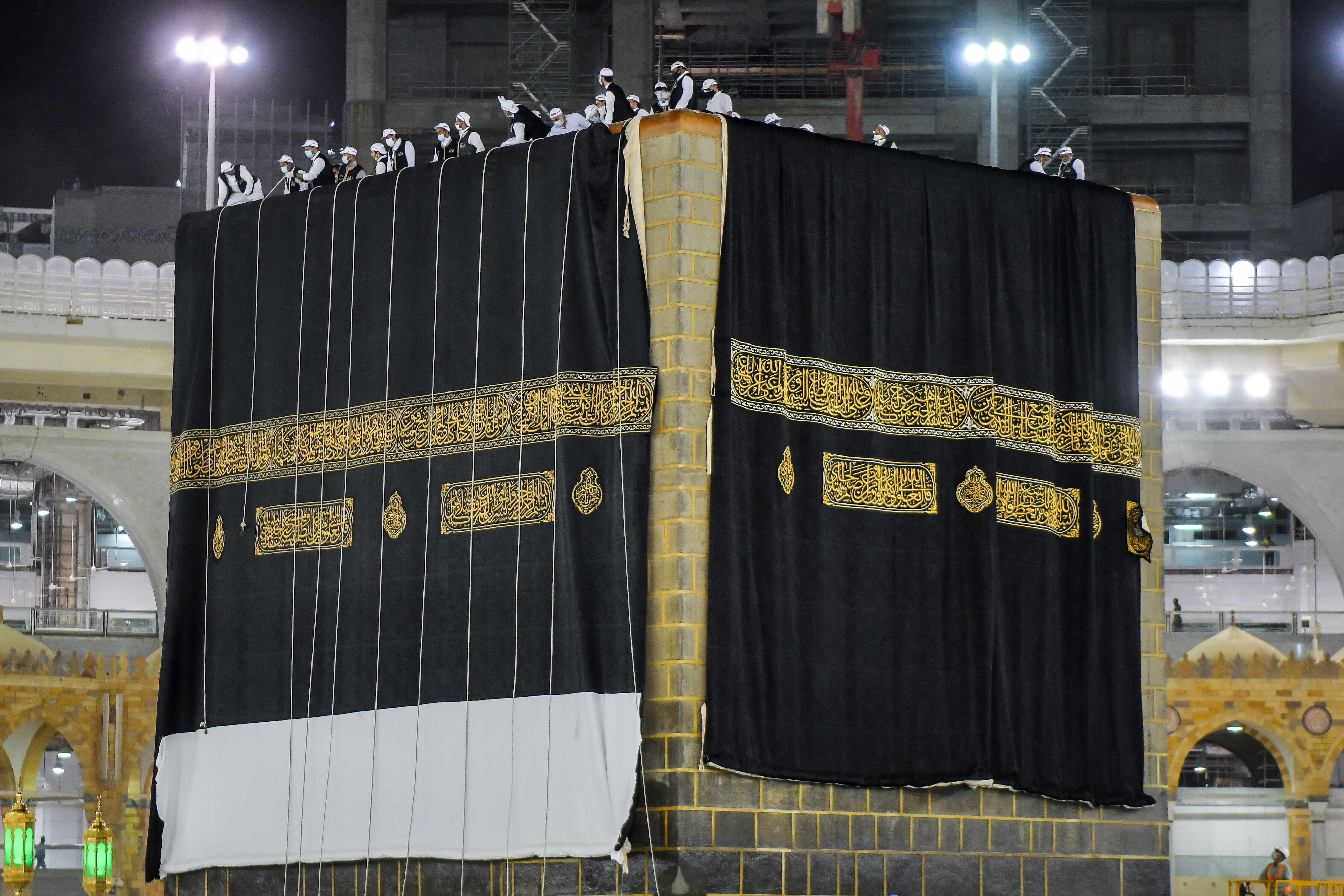 A new kiswa, or covering, is placed atop Islam's holiest site the Kaaba in Mecca on July 29, 2020. The gold-stitched black covering is changed each year during the hajj pilgrimage ahead of the Eid al-Adha celebrations. This year's hajj was dramatically scaled down from 2.5 million pilgrims to as few as 1,000 due to the coronavirus pandemic. (Saudi Media Ministry via AP)