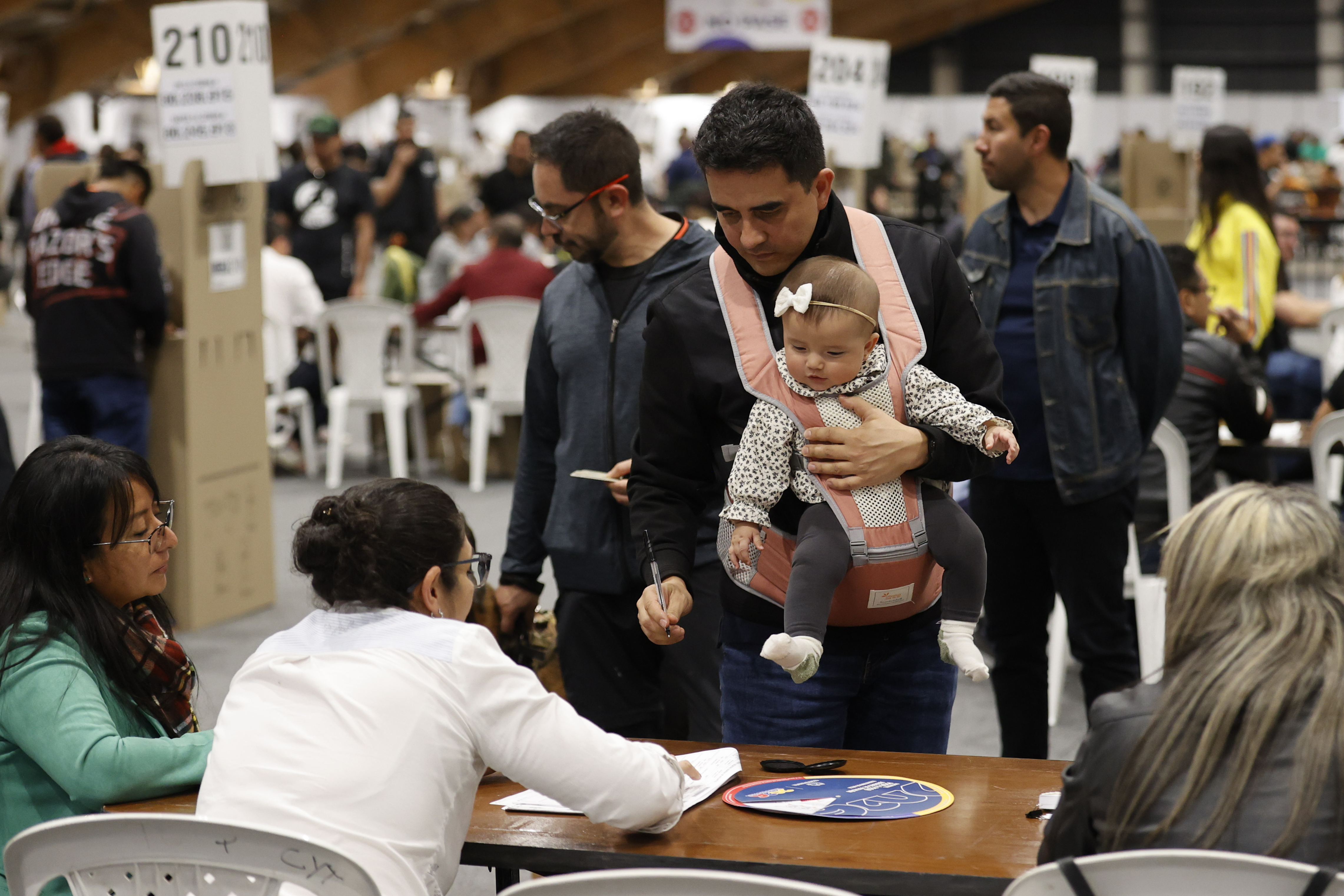 epa13007654 Electoral workers greet voters at a polling station during the presidential election in Bogota, Colombia, 31 May 2026. More than 41 million Colombians are registered to vote. EPA/MAURICIO DUENAS CASTANEDA