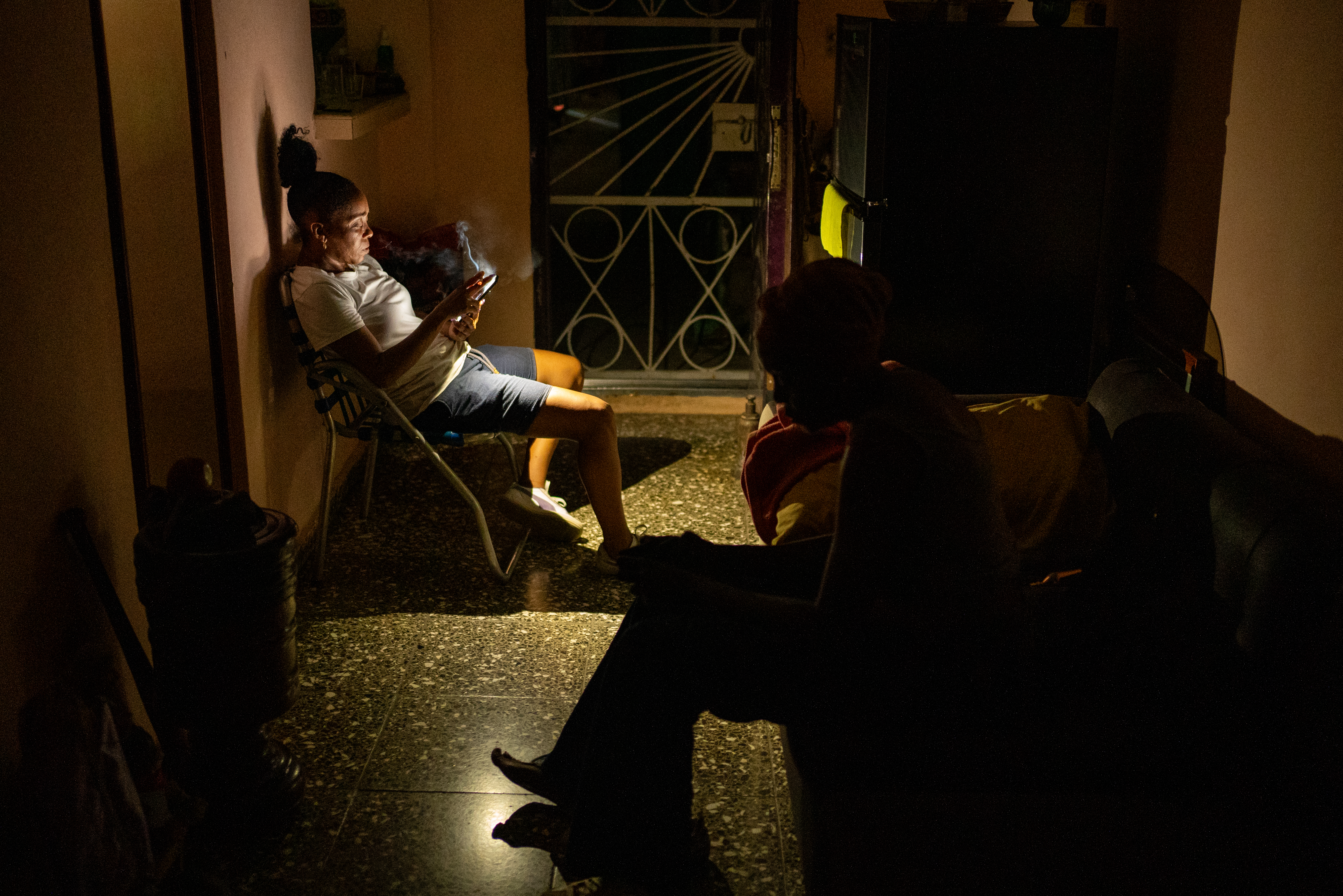 Lazarra Arocena and her sister Dayami wait for the electricity to return in their third-floor apartment in Centro Habana.