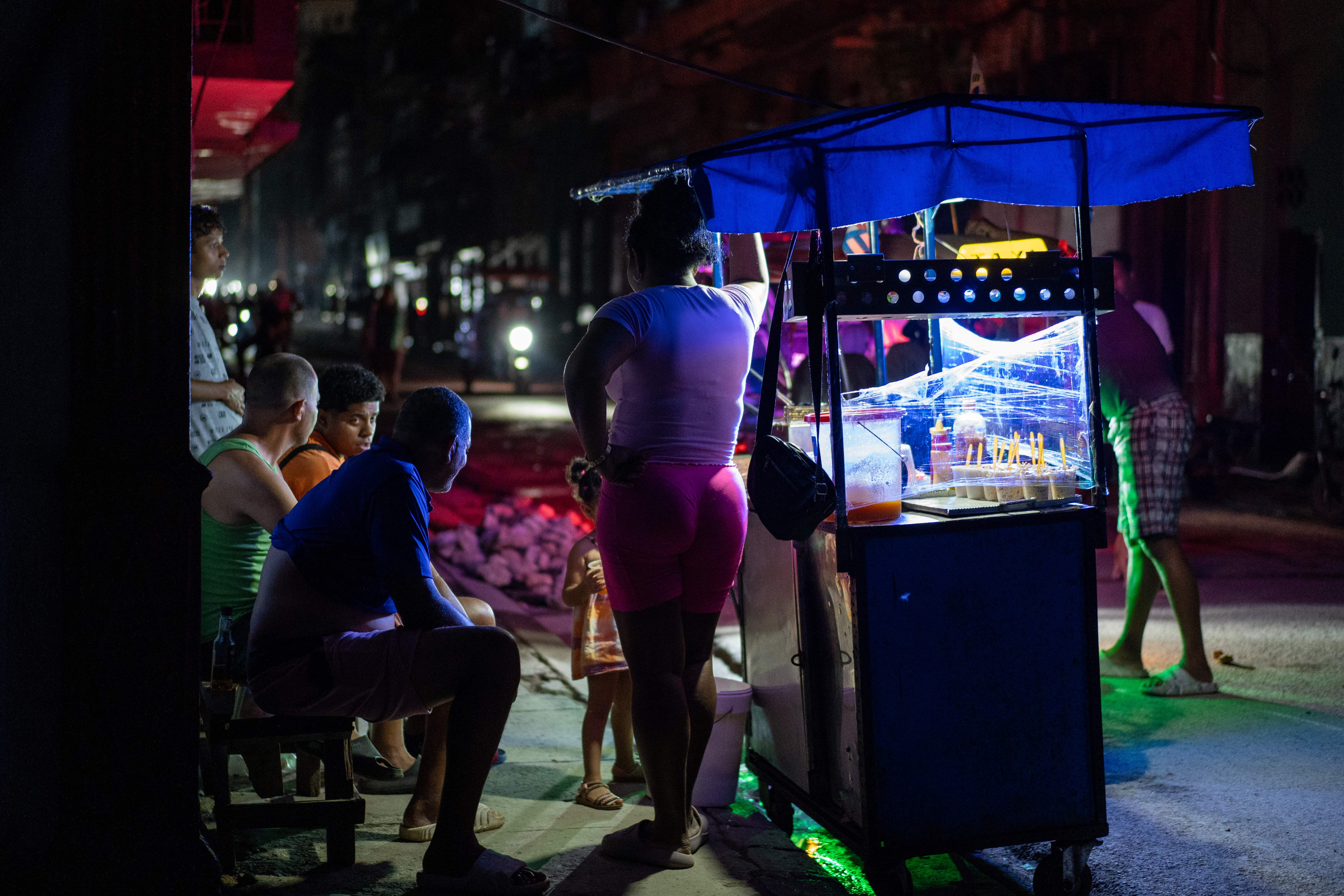 A food vendor works at her stall during a blackout in Centro Habana, Havana. [Al Jazeera]