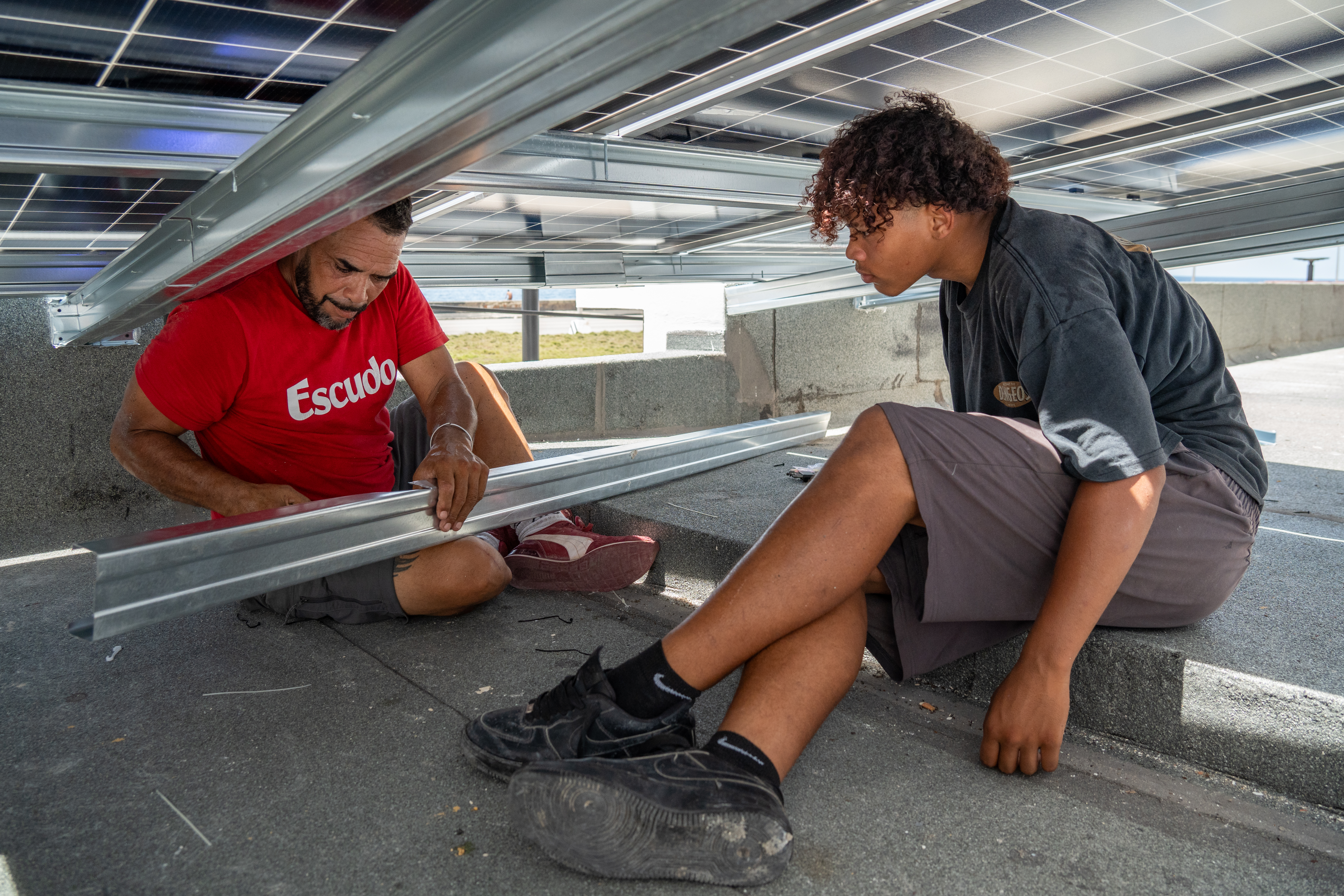 Technicians install solar panels on the roof of the Fuego Lento restaurant along Havana’s Malecón.