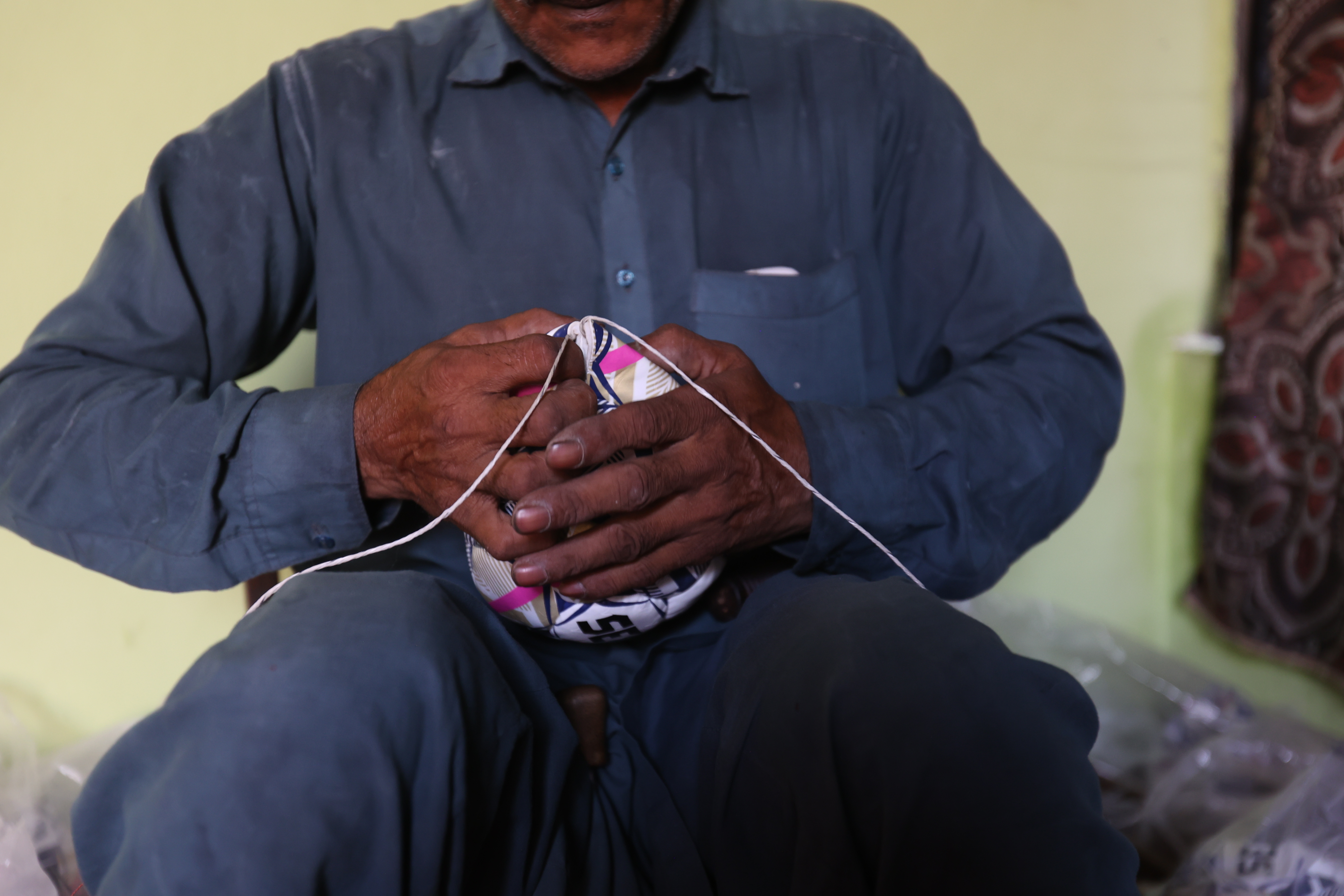 Muhammad Hussain stitches a football