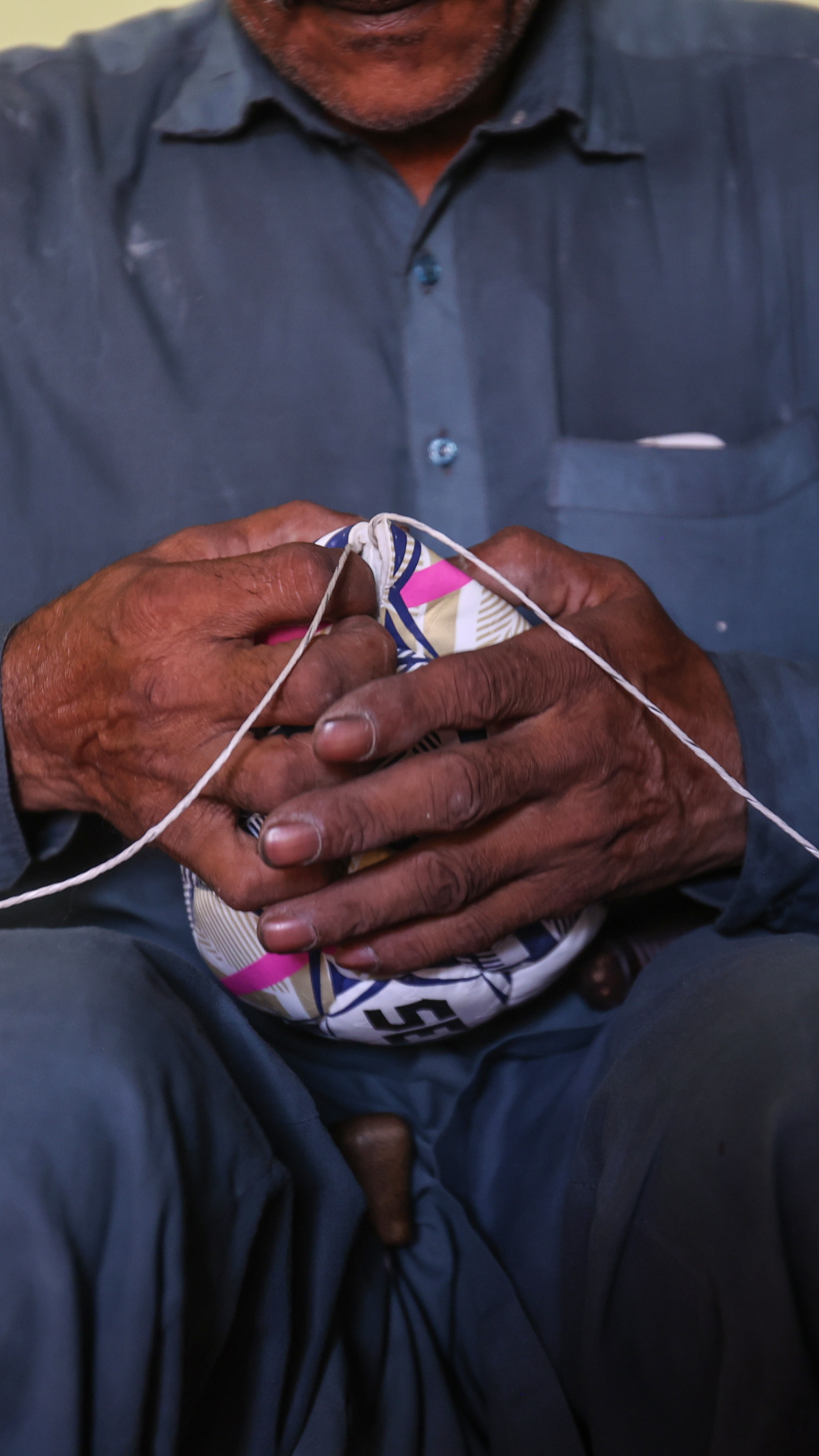 Muhammad Hussain pulls the final stitches into place