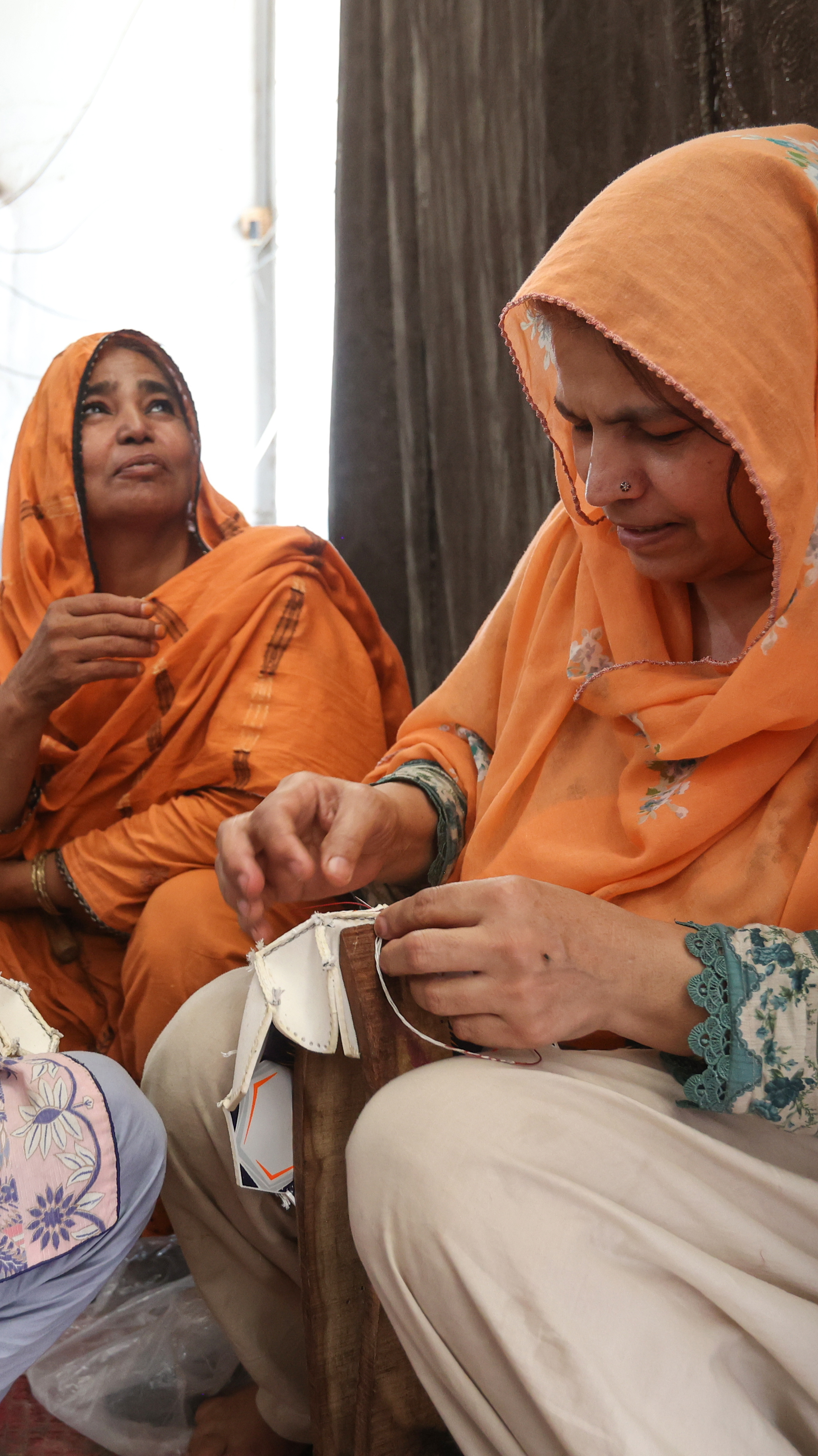 Ansar Majeed (R) has spent 35 years hand-stitching footballs